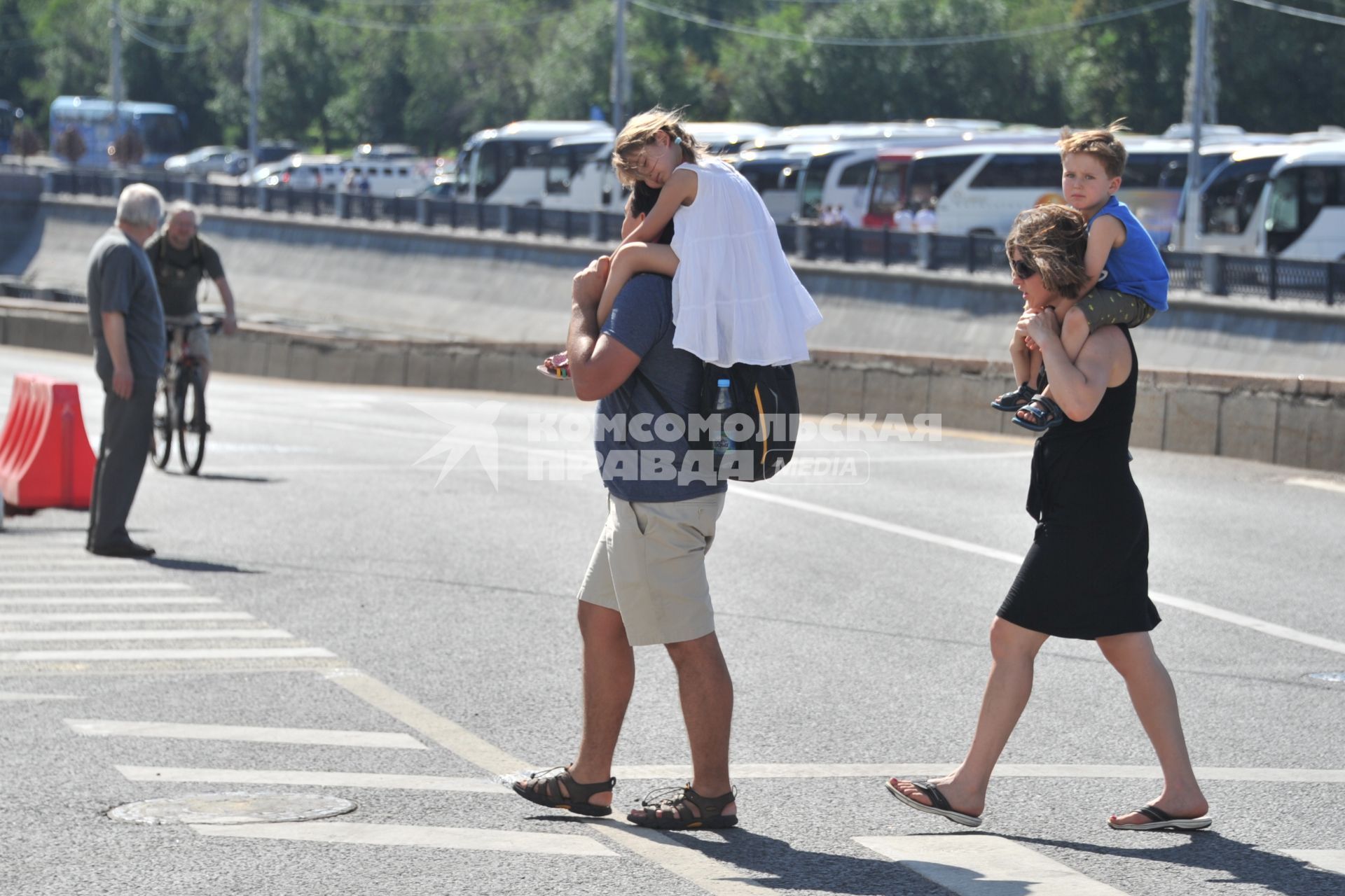 Москва. Родители с детьми на плечах переходят дорогу.