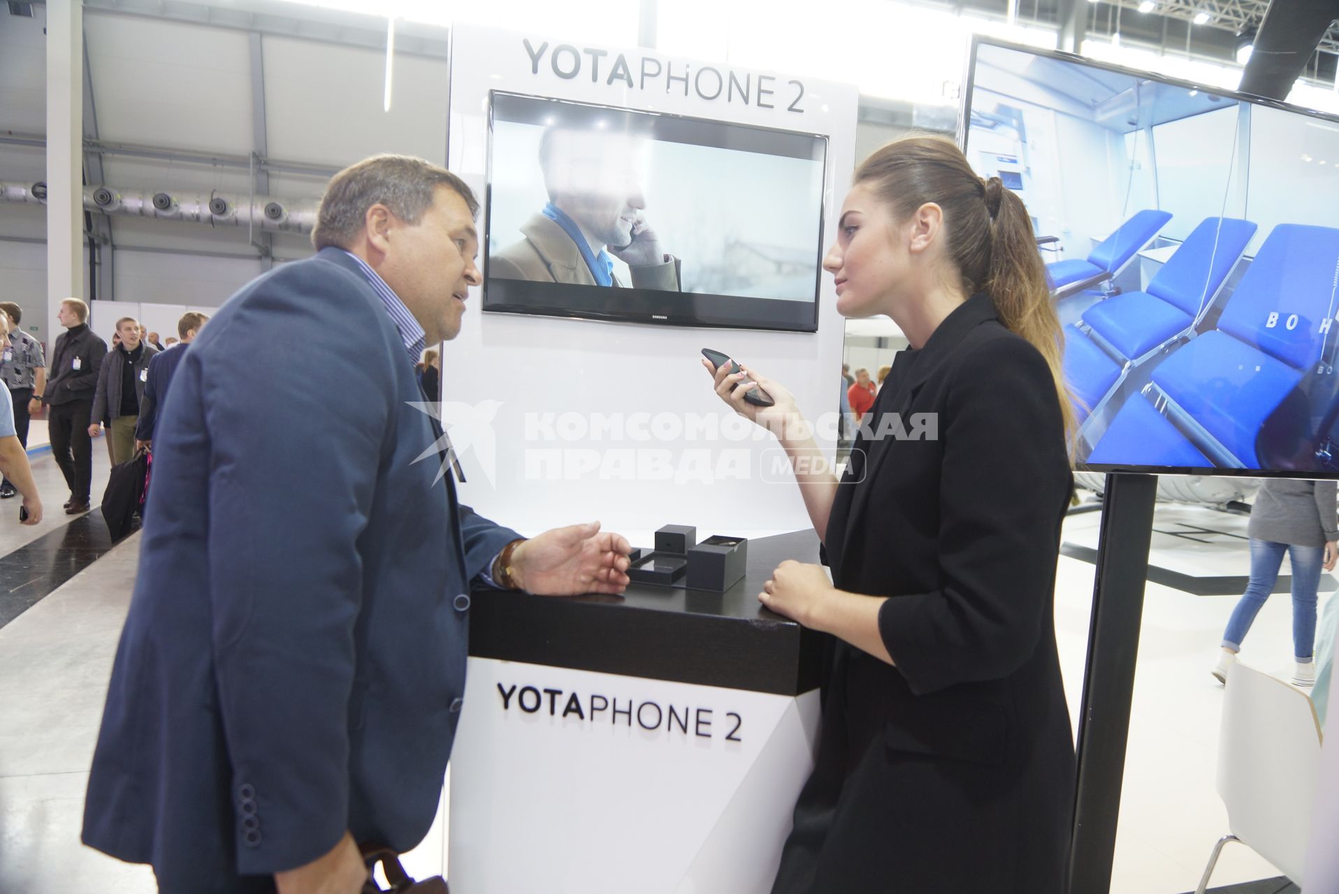 посетитель у стенда компании \"Yota Devices\" презентующей телефон Yotaphone 2. Выставка \"Иннопром - 2015\" . Екатеринбург