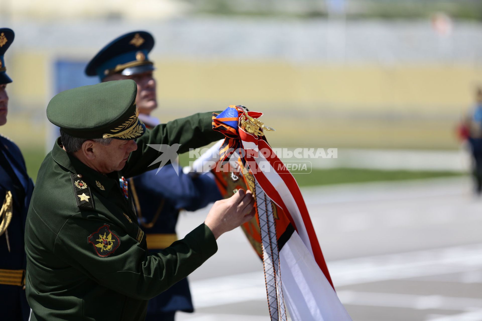 Краснодарский край, пос. Раевский. Министр обороны РФ генерал армии Сергей Шойгу прикрепляет орден Суворова на знамя 7-й гвардейской Краснознаменной десантно-штурмовой (горной) дивизии.