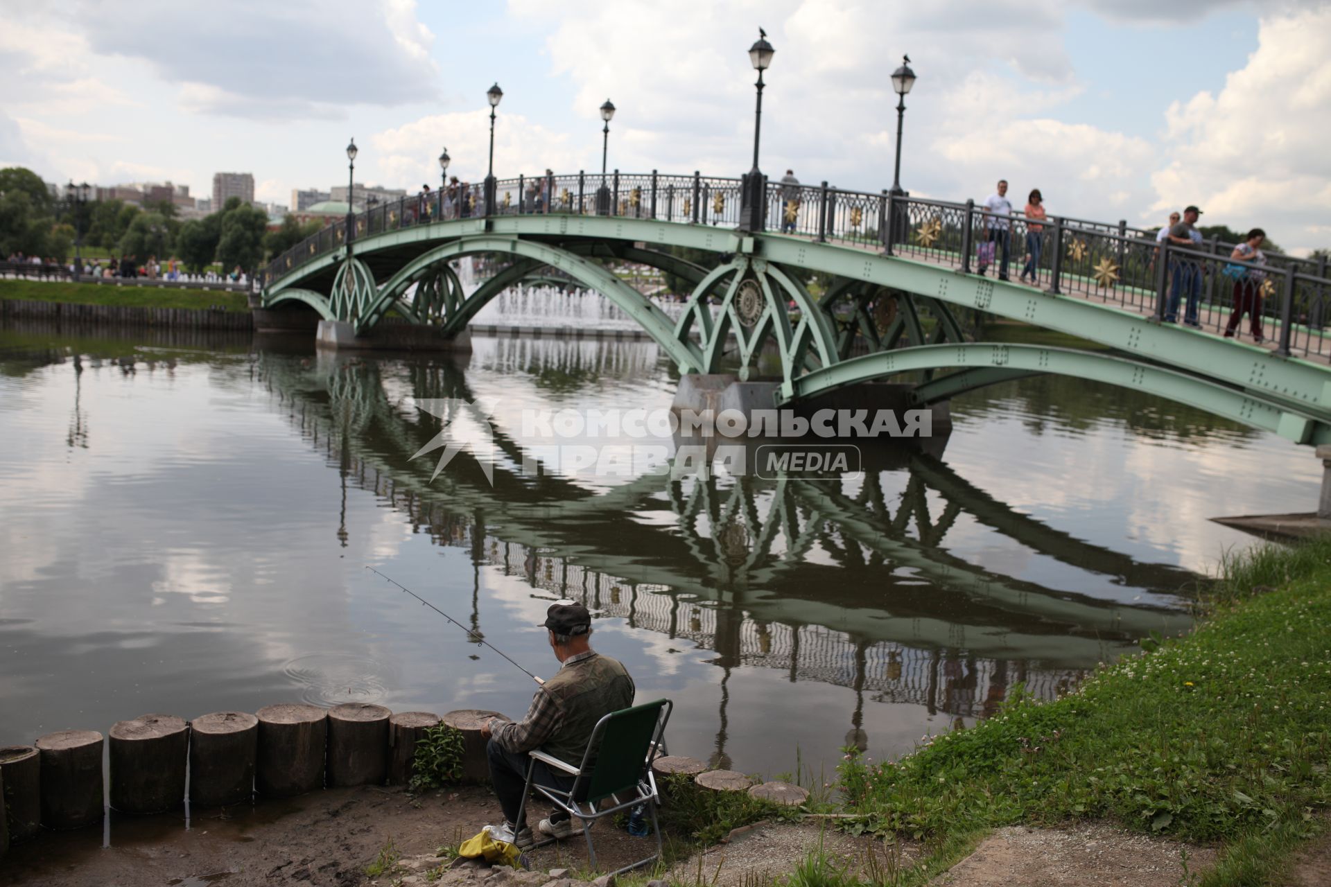 Москва. Мужчина ловит рыбу возле пешеходного моста в парке Царицыно.