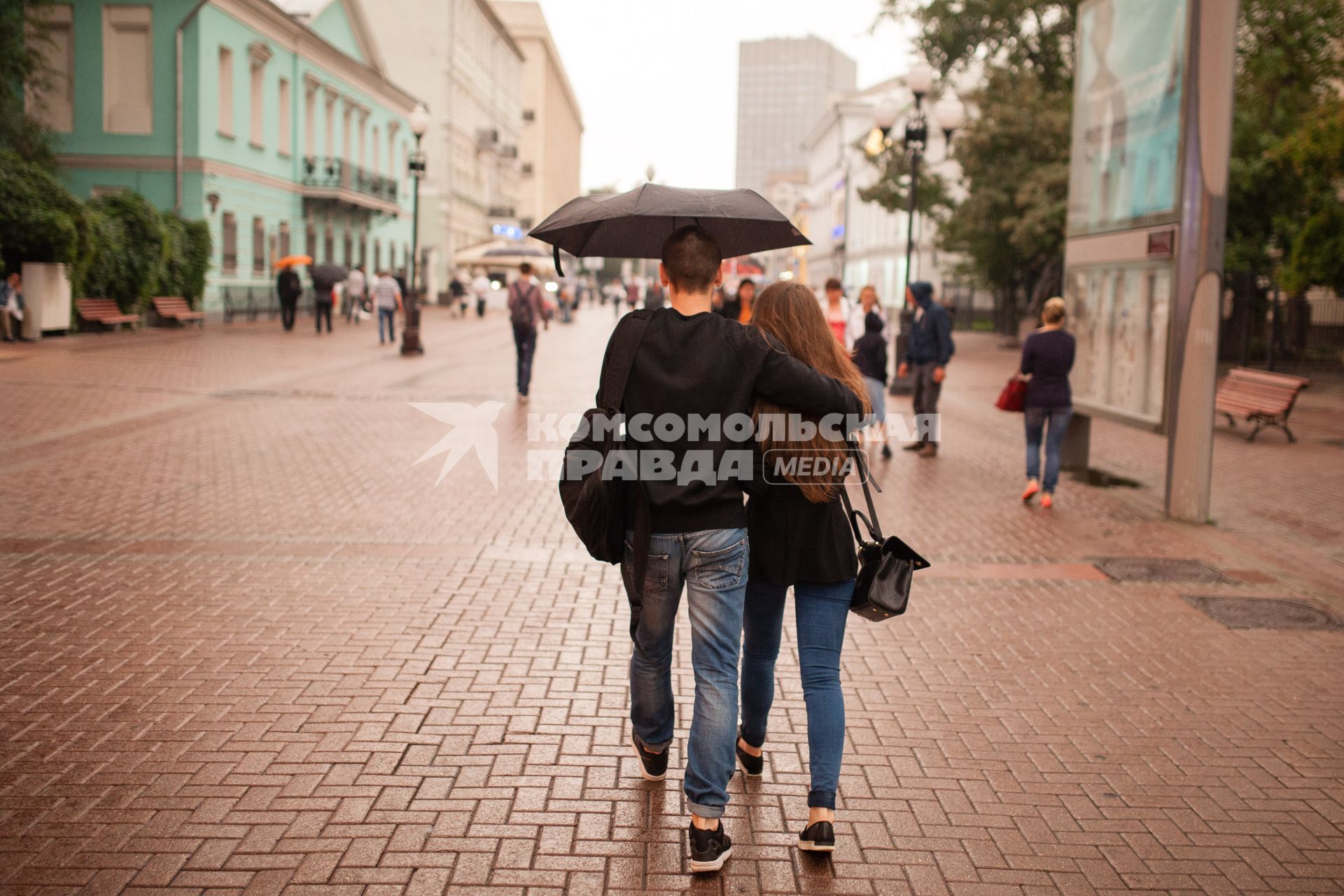 Москва. Молодая пара идет под зонтом по Старому Арбату.