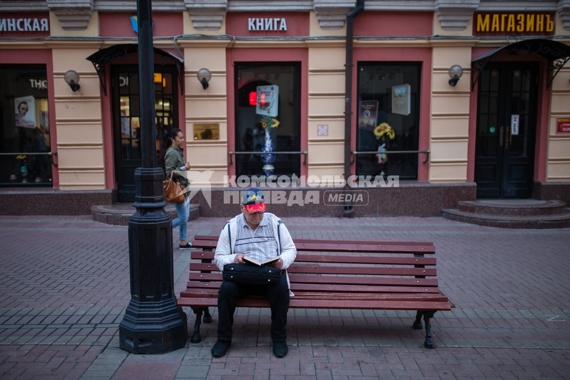 Москва. Пожилой мужчина отдыхает на скамейке на Старом Арбате.