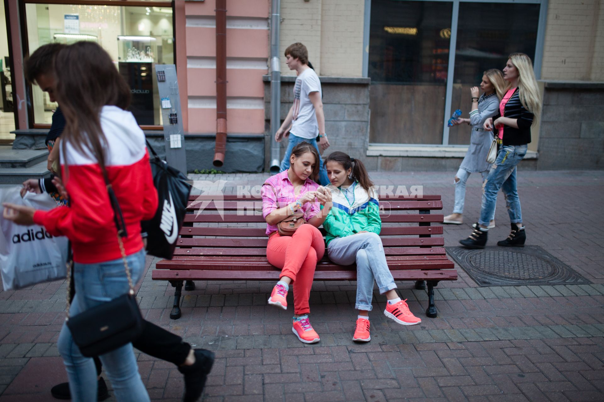 Москва. Девушки сидят на скамейке на Старом Арбате.