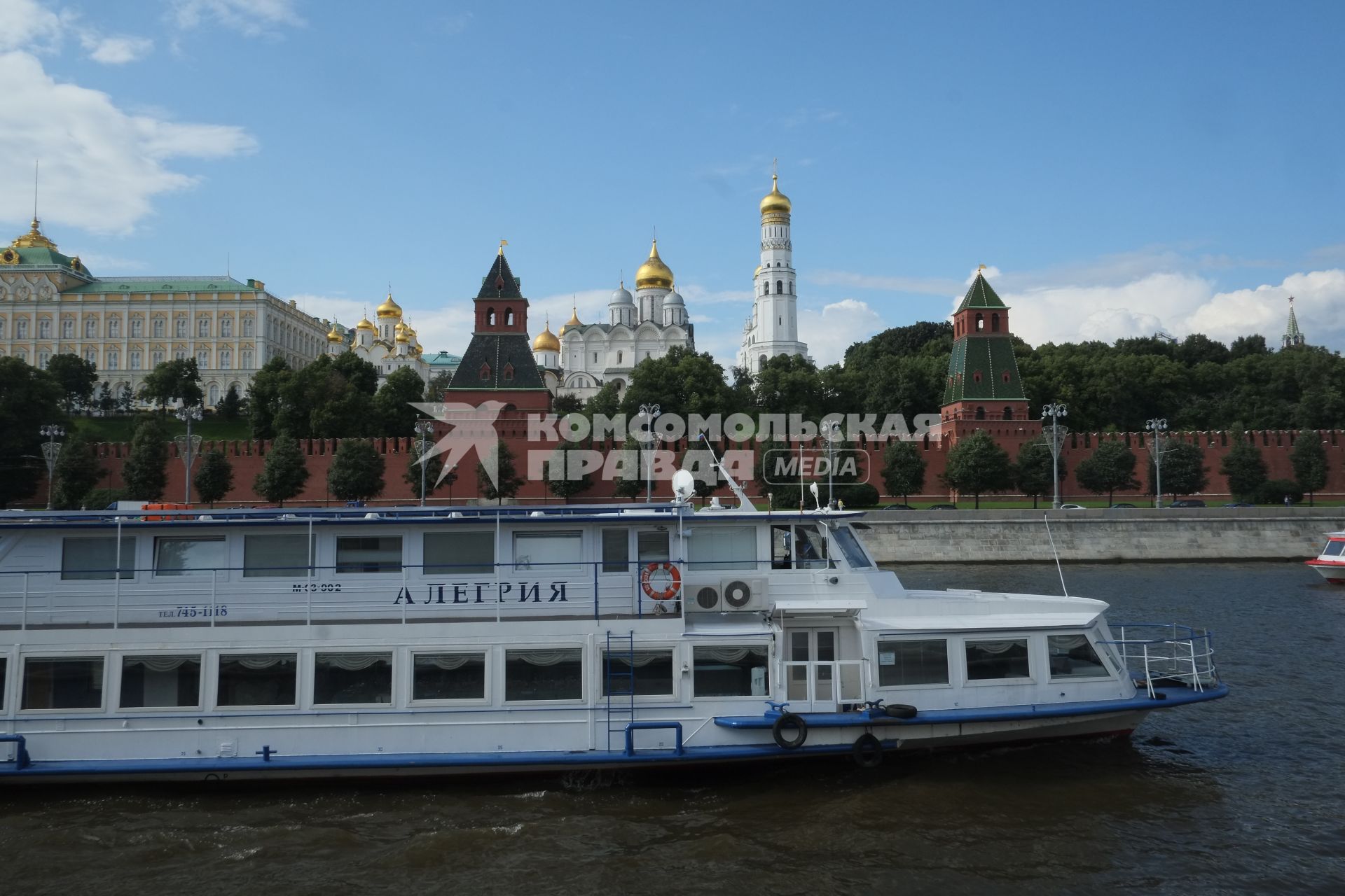 Москва. Прогулочный теплоход плывет по Москва-реке мимо Кремлевской набережной.