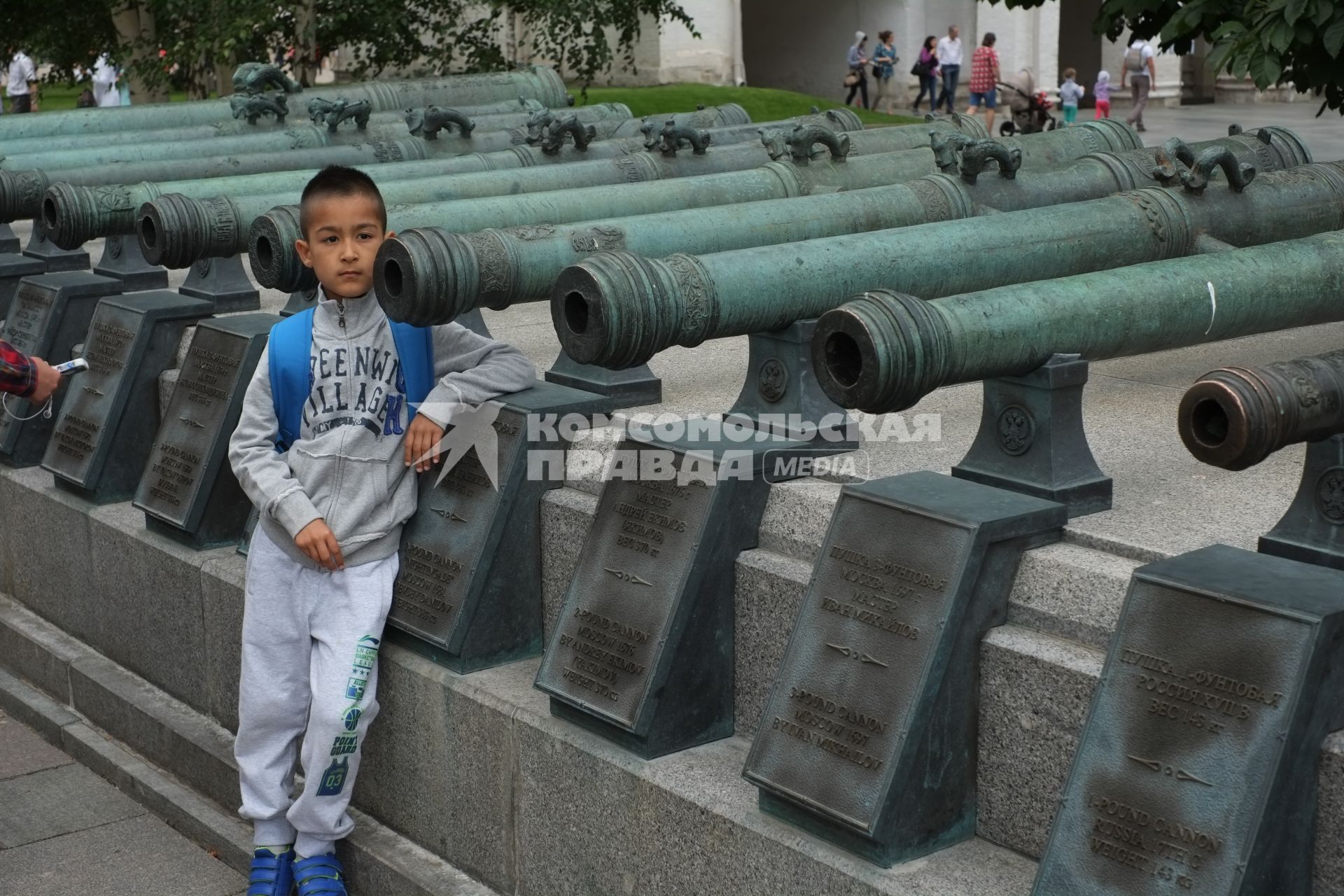 Московский Кремль. Мальчик стоит у старинных пушек на Соборной площади.