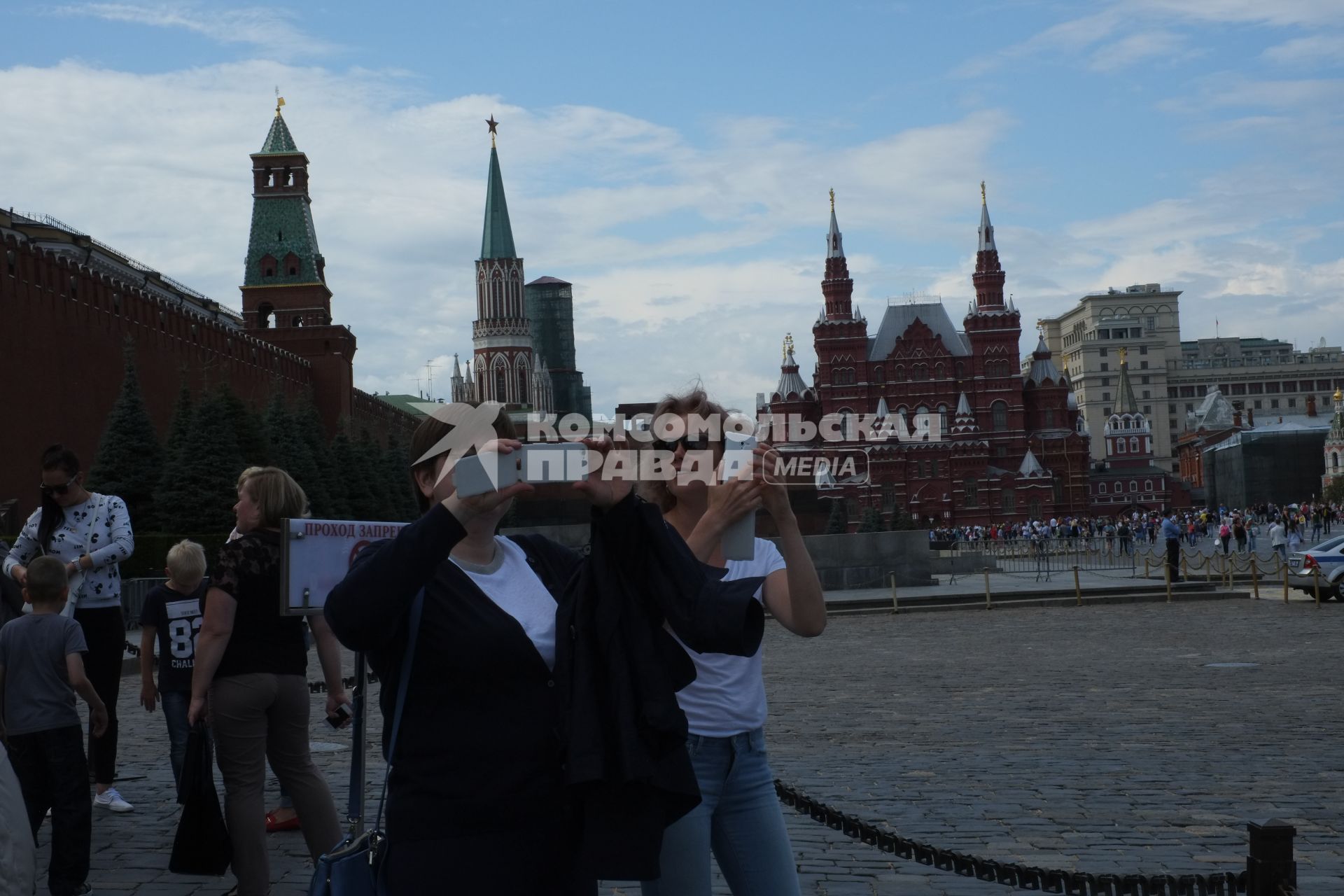 Москва. Девушки фотографируют на мобильный телефон Красную площадь.