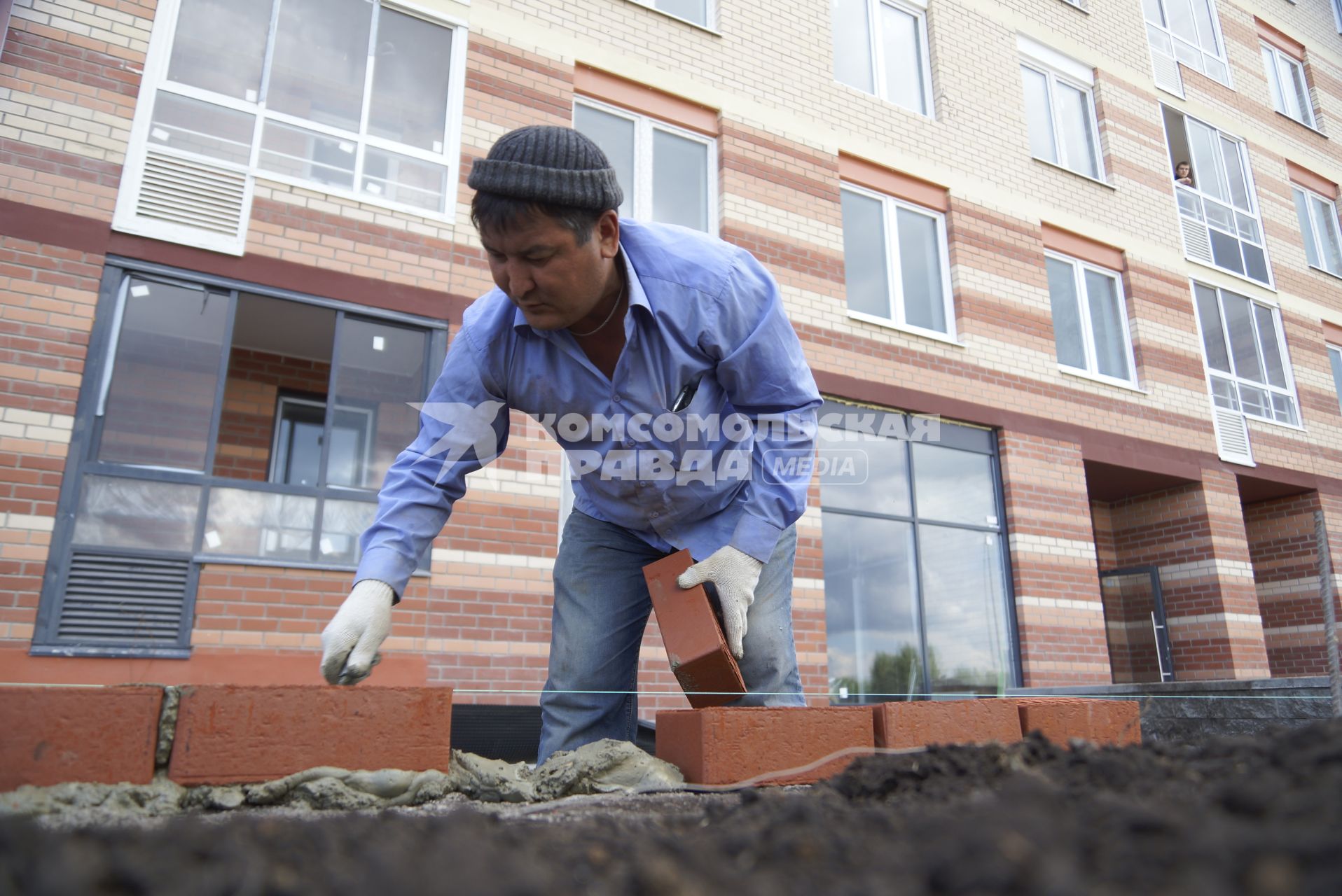 Рабочий делает кирпичную кладку. Строительство многоэтажного дома в районе \"Солнечный\". Екатеринбург