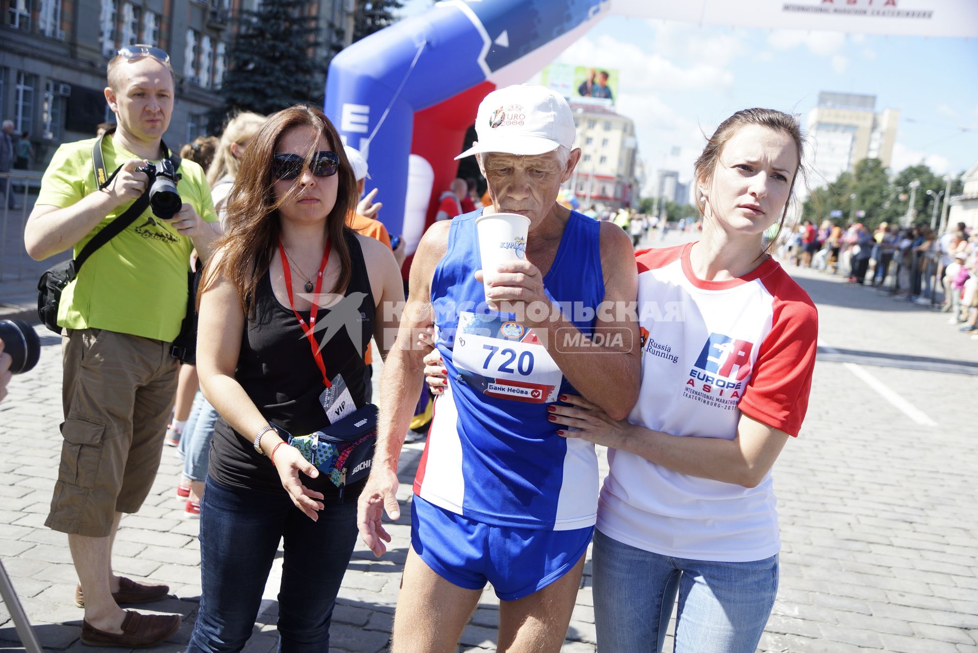 Волонтеры на финише помогают пожилому марафонцу, пробежавшему 42км во время первого международного марафона \"Европа-Азия\". Екатеринбург