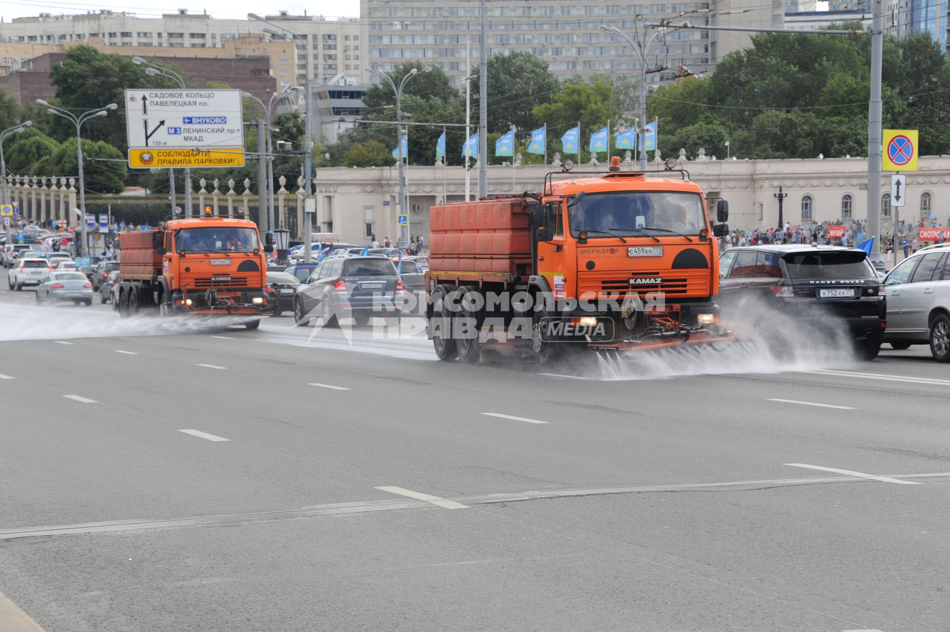 Москва. Поливальные машины моют дорогу  на Крымском мосту.