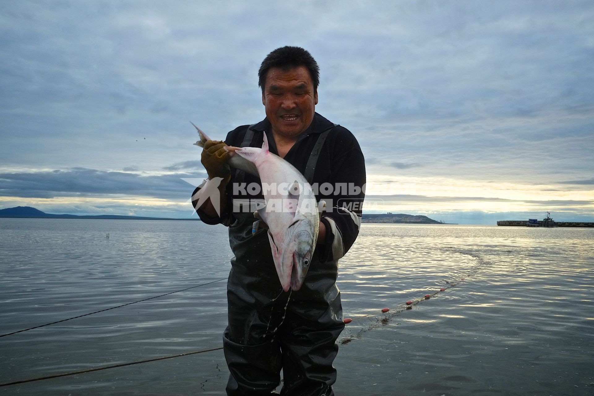 Чукотская АО. Мужчина держит в руках рыбу кету, пойманную в Анадырском лимане.