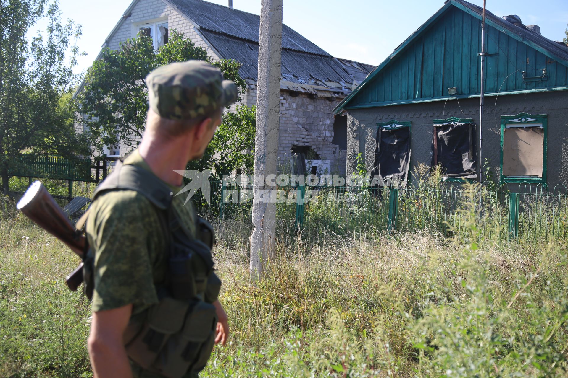 Украина. Донецкая область. Шахтный поселок 6/7. Ополченец ДНР идут мимо разрушенных домов.