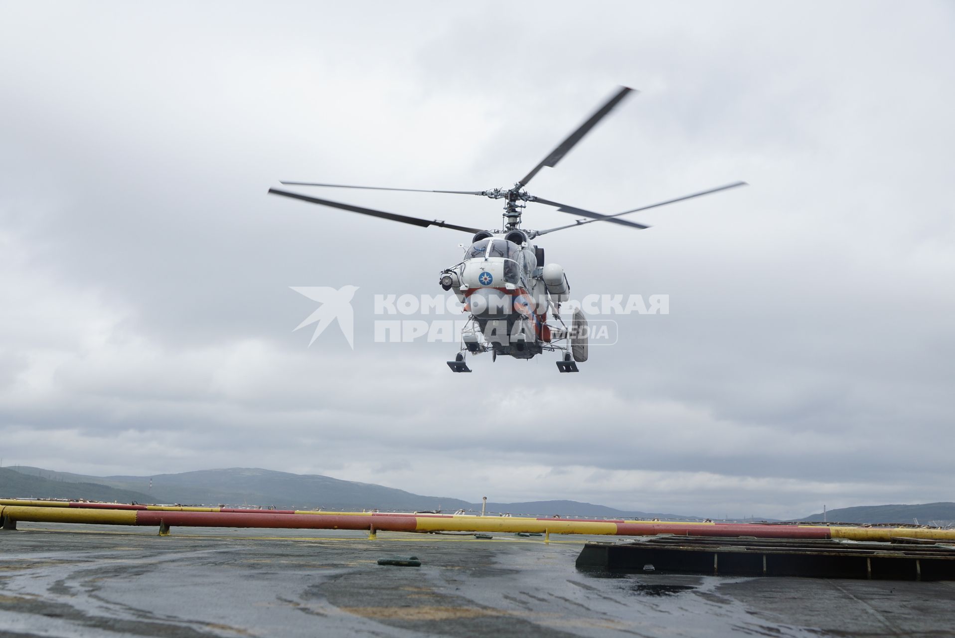 Вертолет МЧС России Ка-32А11ВС отрабатывает посадку на палубу дизельного ледокола \"Капитан Драницын\", перед отправкой на северный полюс, для эвакуации сезонной дрейфующей станции \"Северный полюс 2015\". Мурманск