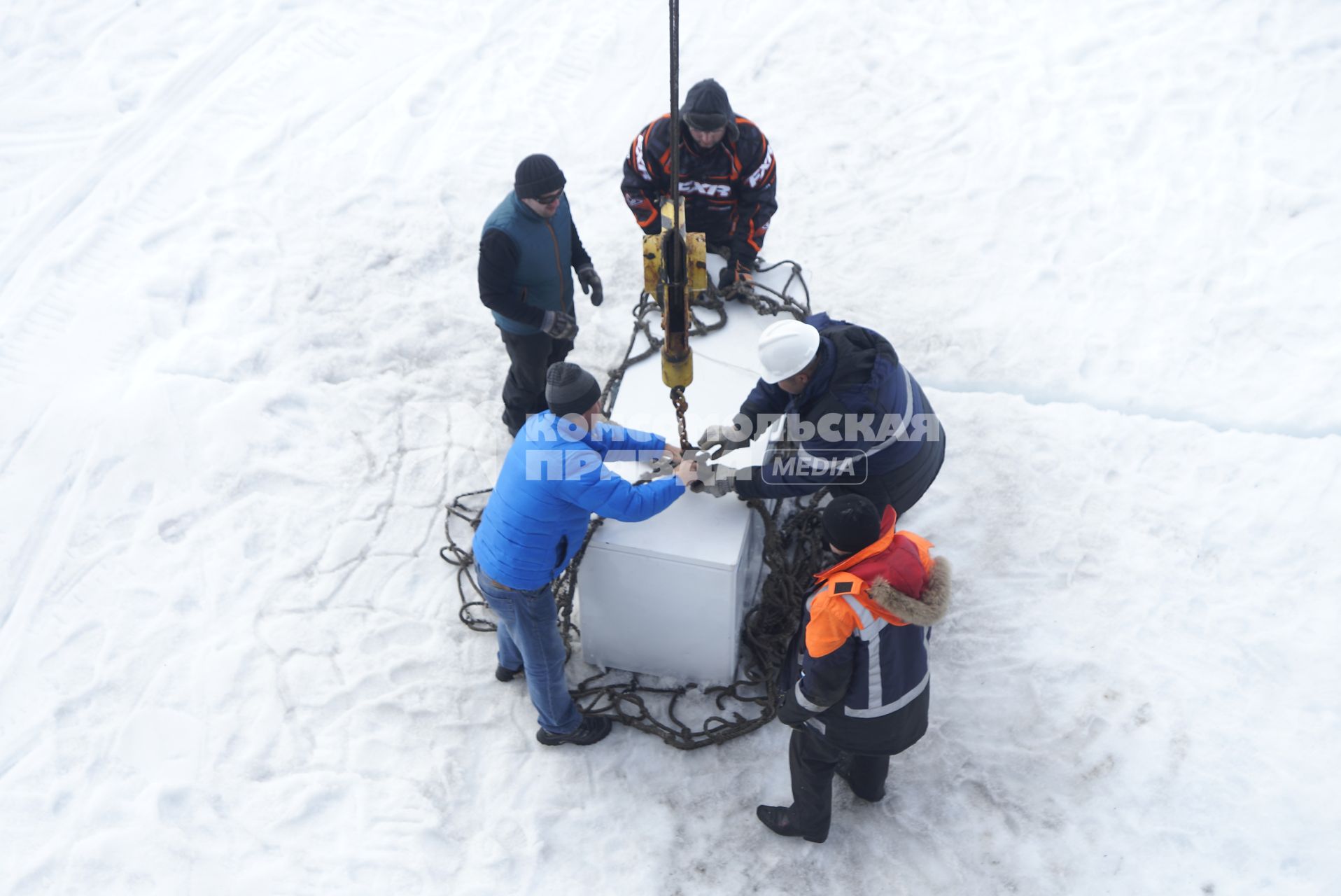 Полярники грузят холодильник с продуками с сезонной дрейфующей станции \"Северный полюс 2015\" в сетку, для погрузки в трюм ледокола \"Капитан Драницын\" перед эвакуацией на большую землю. Северный полюс. Северный ледовитый океан