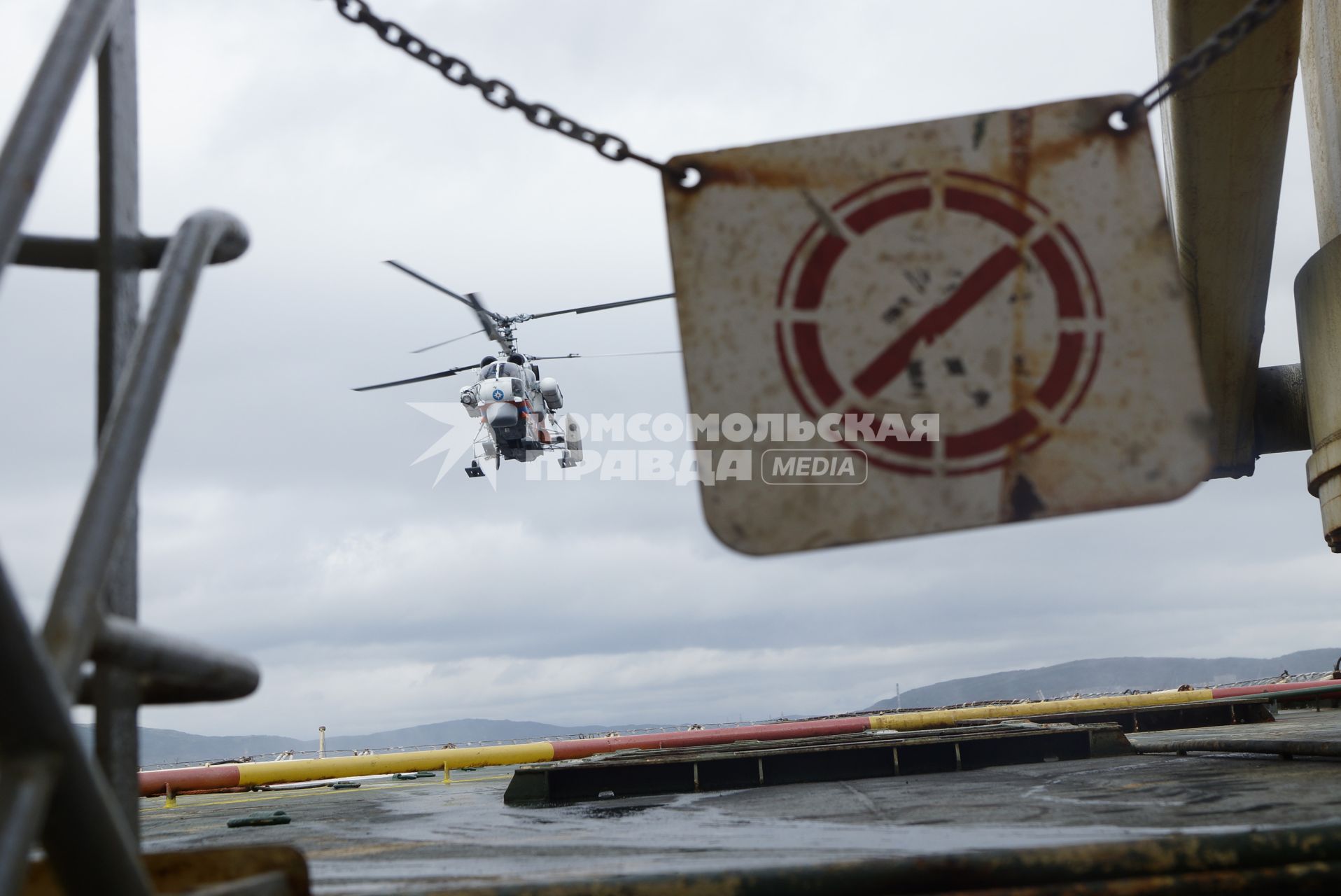 Вертолет МЧС России Ка-32А11ВС отрабатывает посадку на палубу дизельного ледокола \"Капитан Драницын\", перед отправкой на северный полюс, для эвакуации сезонной дрейфующей станции \"Северный полюс 2015\". Мурманск