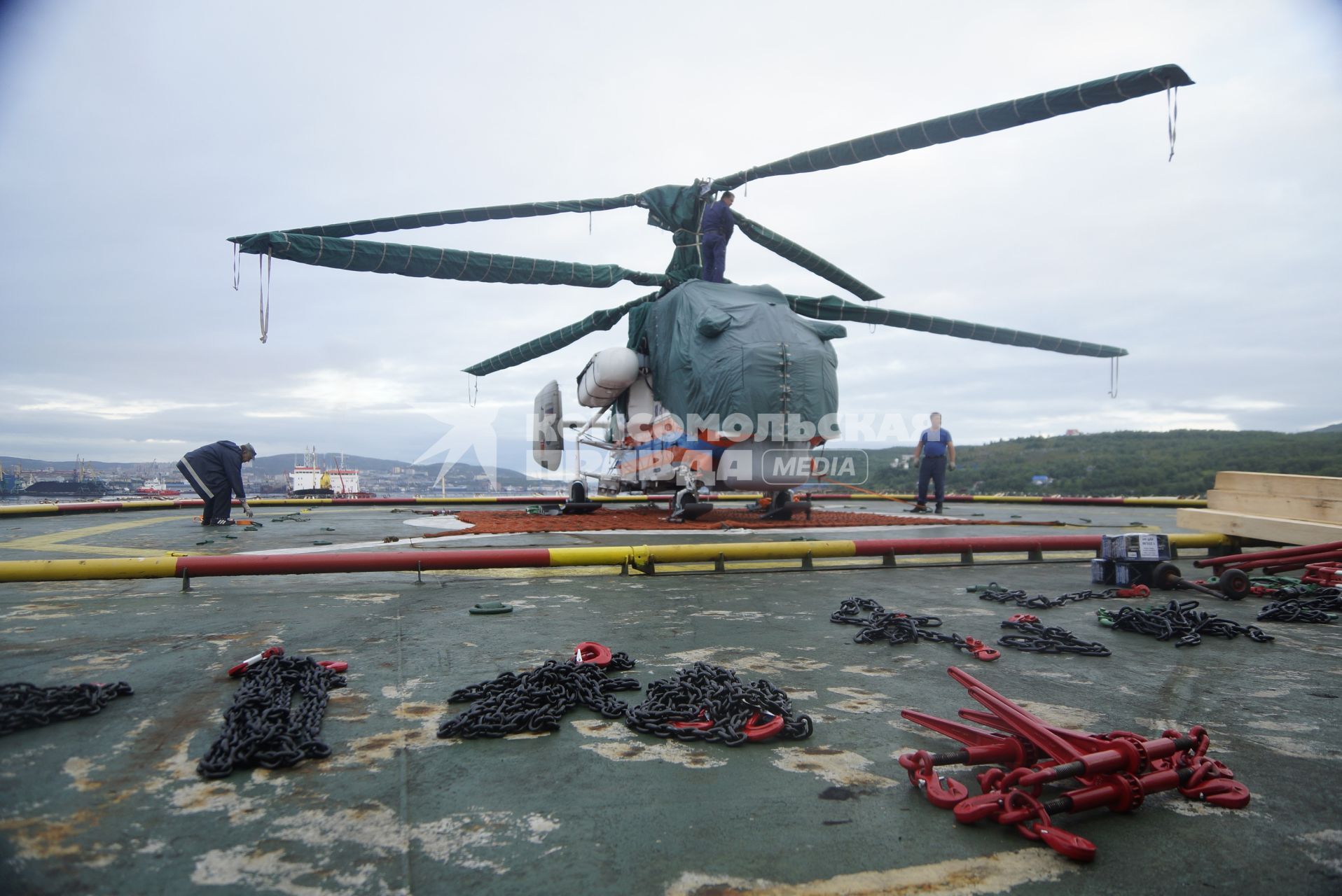 Зачехленый вертолет МЧС России Ка-32А11ВС на палубе дизельного ледокола \"Капитан Драницын\", перед отправкой на северный полюс, для эвакуации сезонной дрейфующей станции \"Северный полюс 2015\". Мурманск