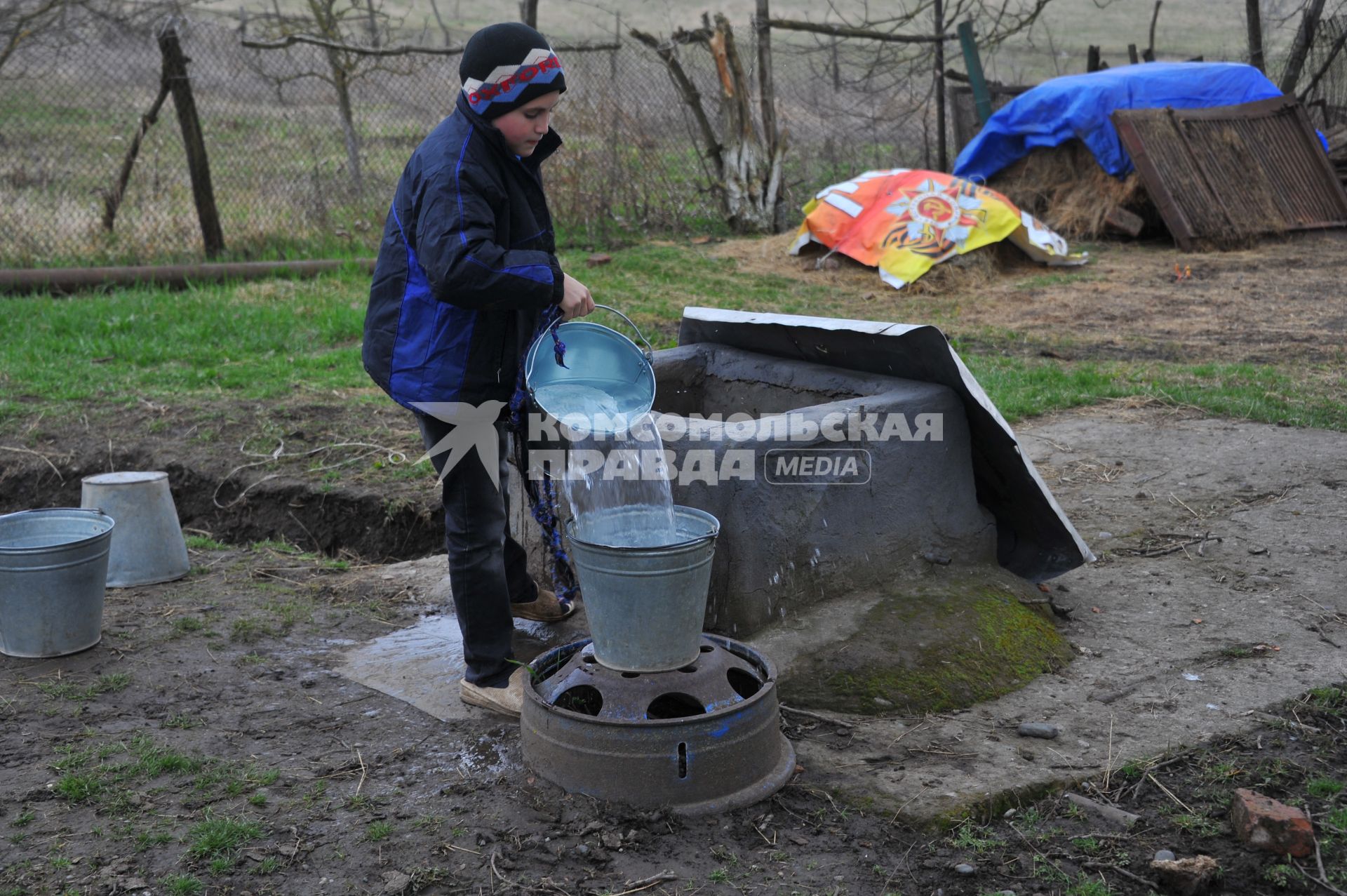 Ингушетия. Станица Вознесенская. Мальчик наливает воду из колодца.