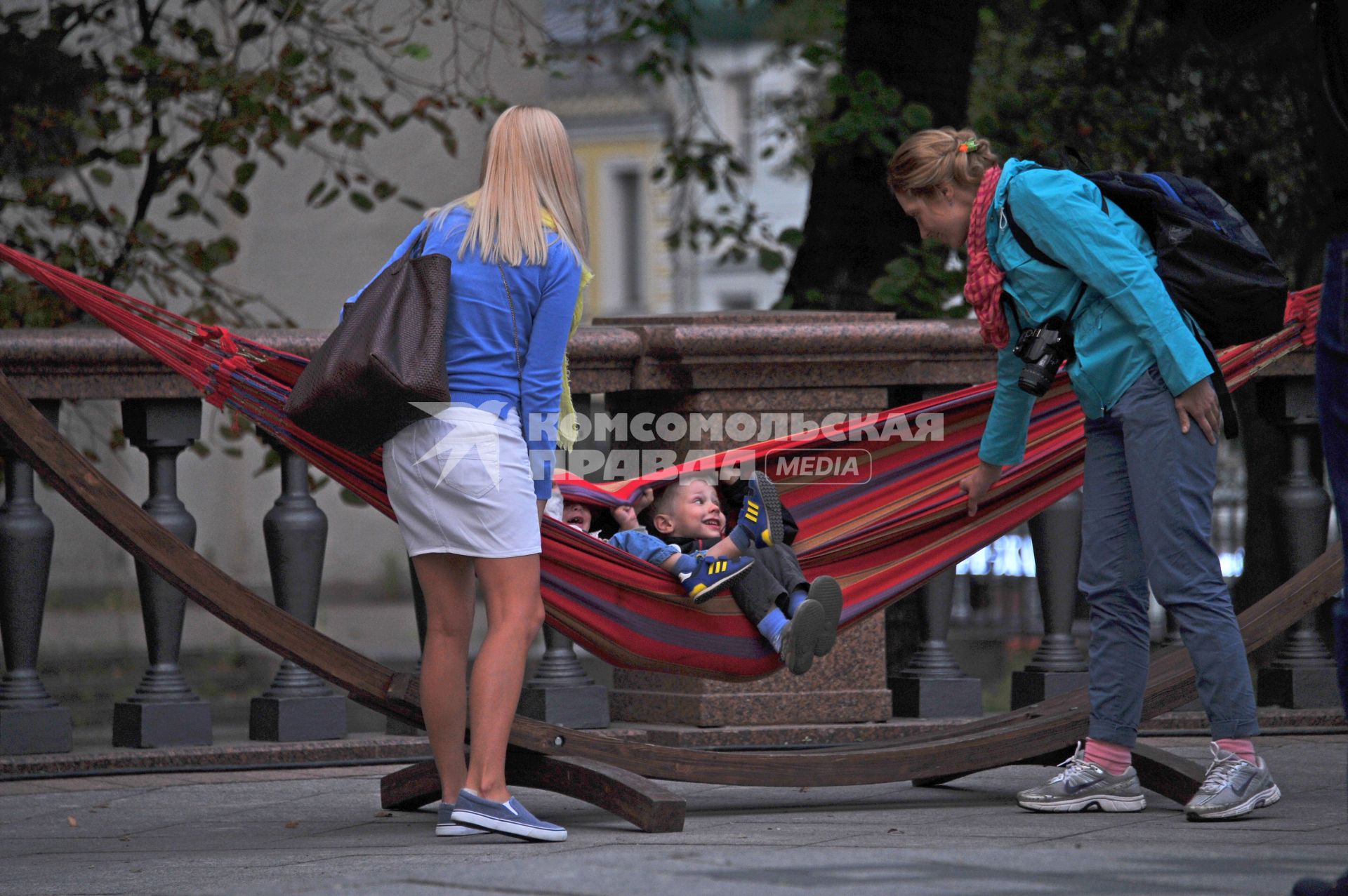 Москва. Дети лежат в гамаке на Тверской площади.