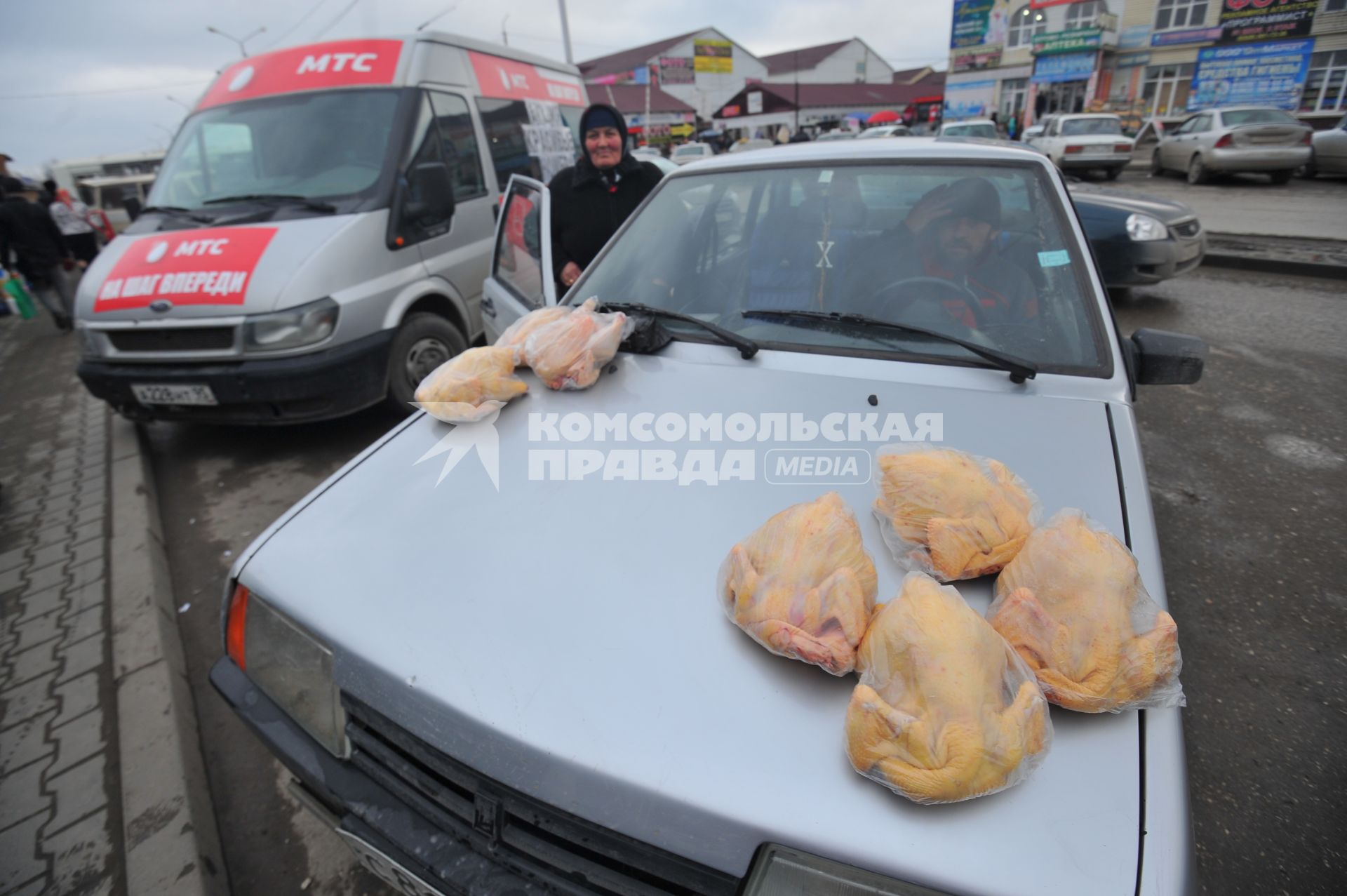 Чечня. Грозный. Женщина продает куриные тушки с машины.