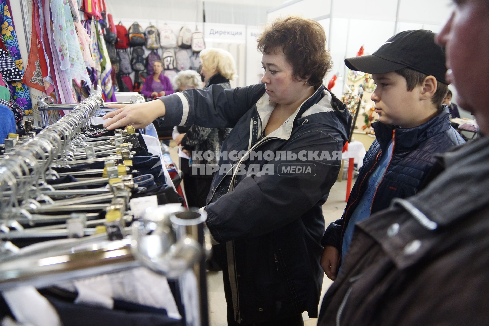 Екатеринбург. Покупатели выбирают одежду на школьном базаре.