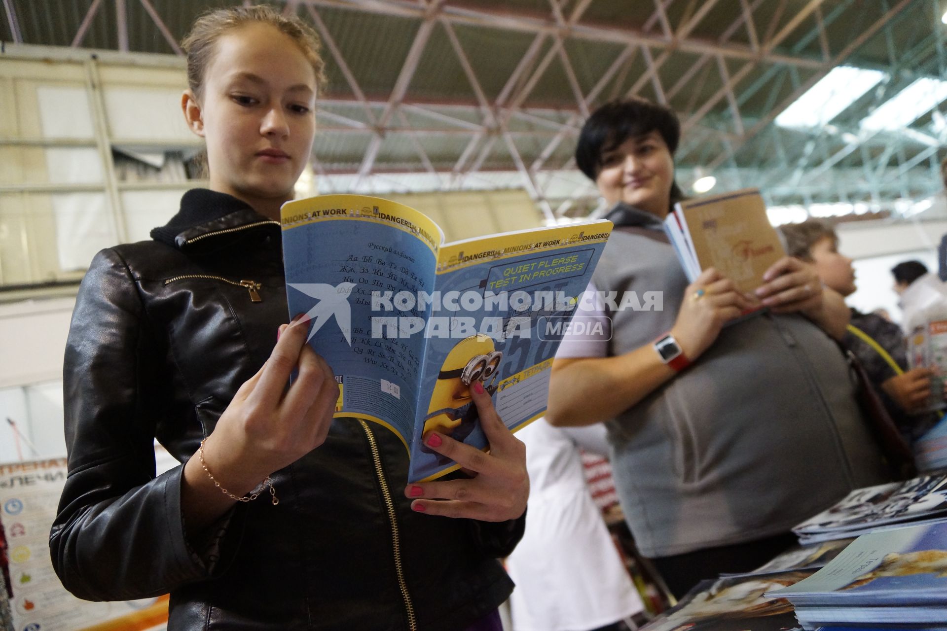 Екатеринбург. Девочка выбирает тетрадь на школьном базаре.