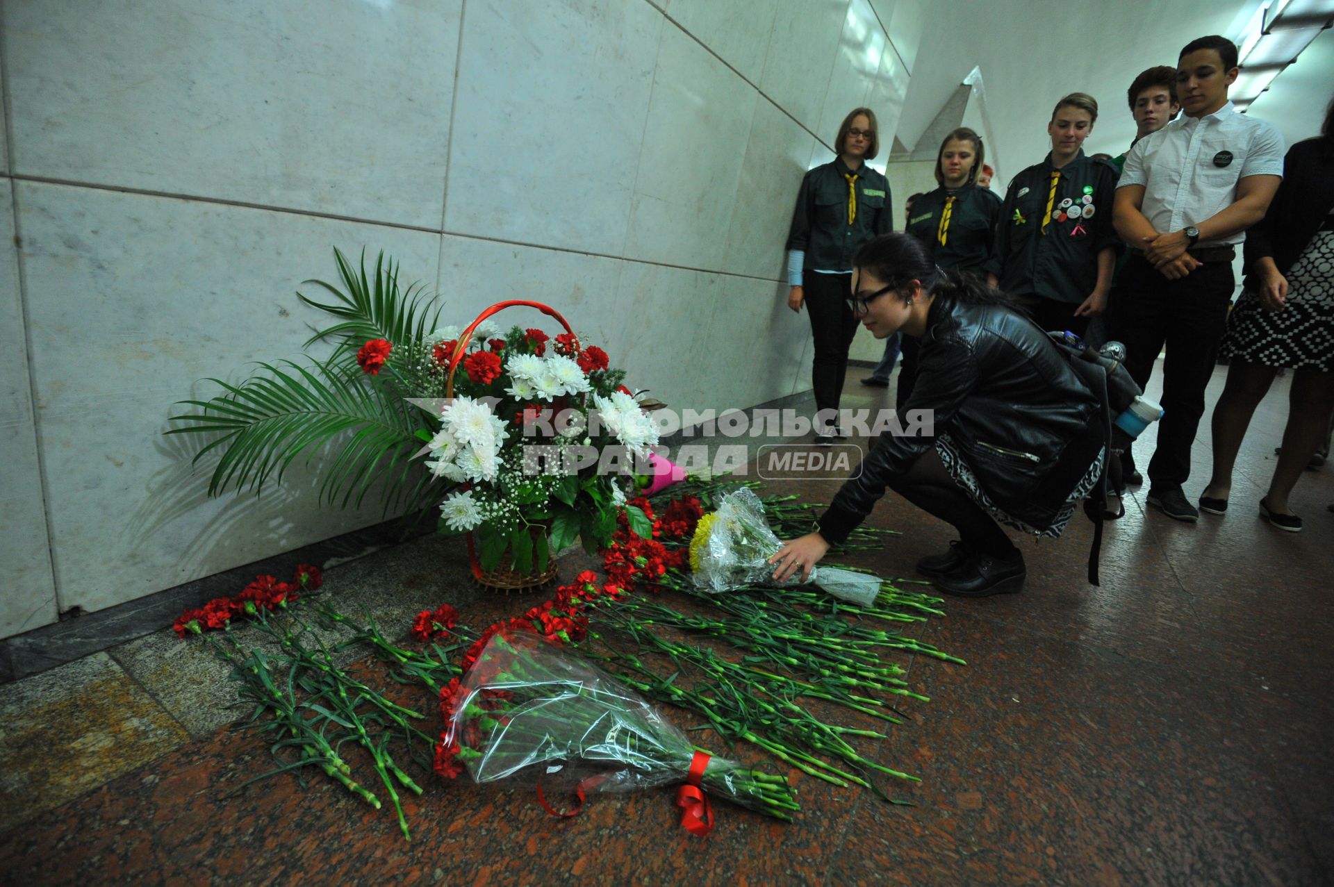 Москва.  Девушка возлагает цветы во время акции памяти жертв терроризма в вестибюле станции метро Лубянка.