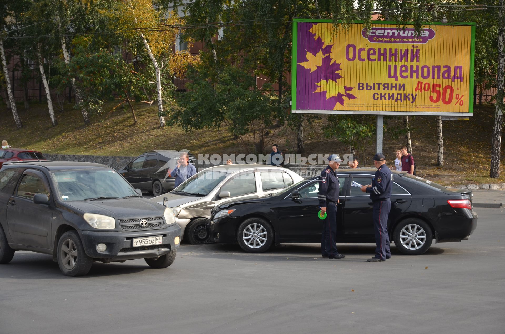Новосибирск. ДТП на фоне плаката `Осенний ценопад`.
