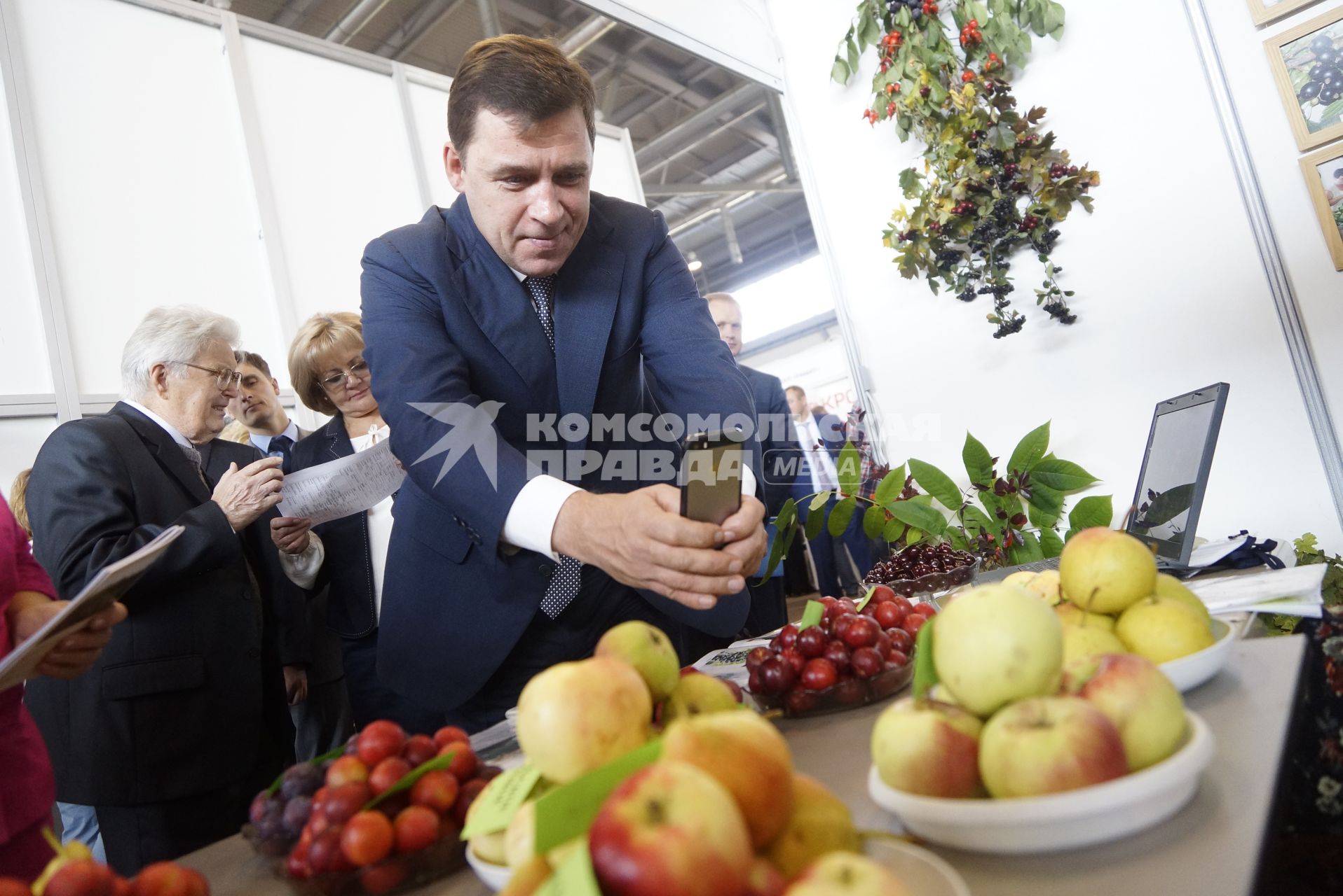 Екатеринбург. 16-ая Агропромышленная выставка. Губернатор Свердловской области Евгений Куйвашев фотографирует черешню и ялоки на свой моибльный телефон.