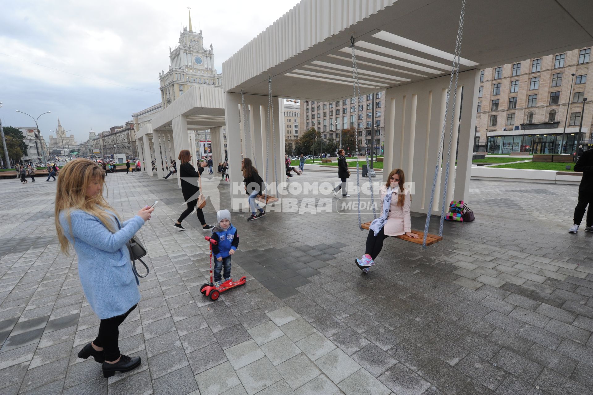 Москва. Девушка качается на качелях на Триумфальной площади после реконструкции.