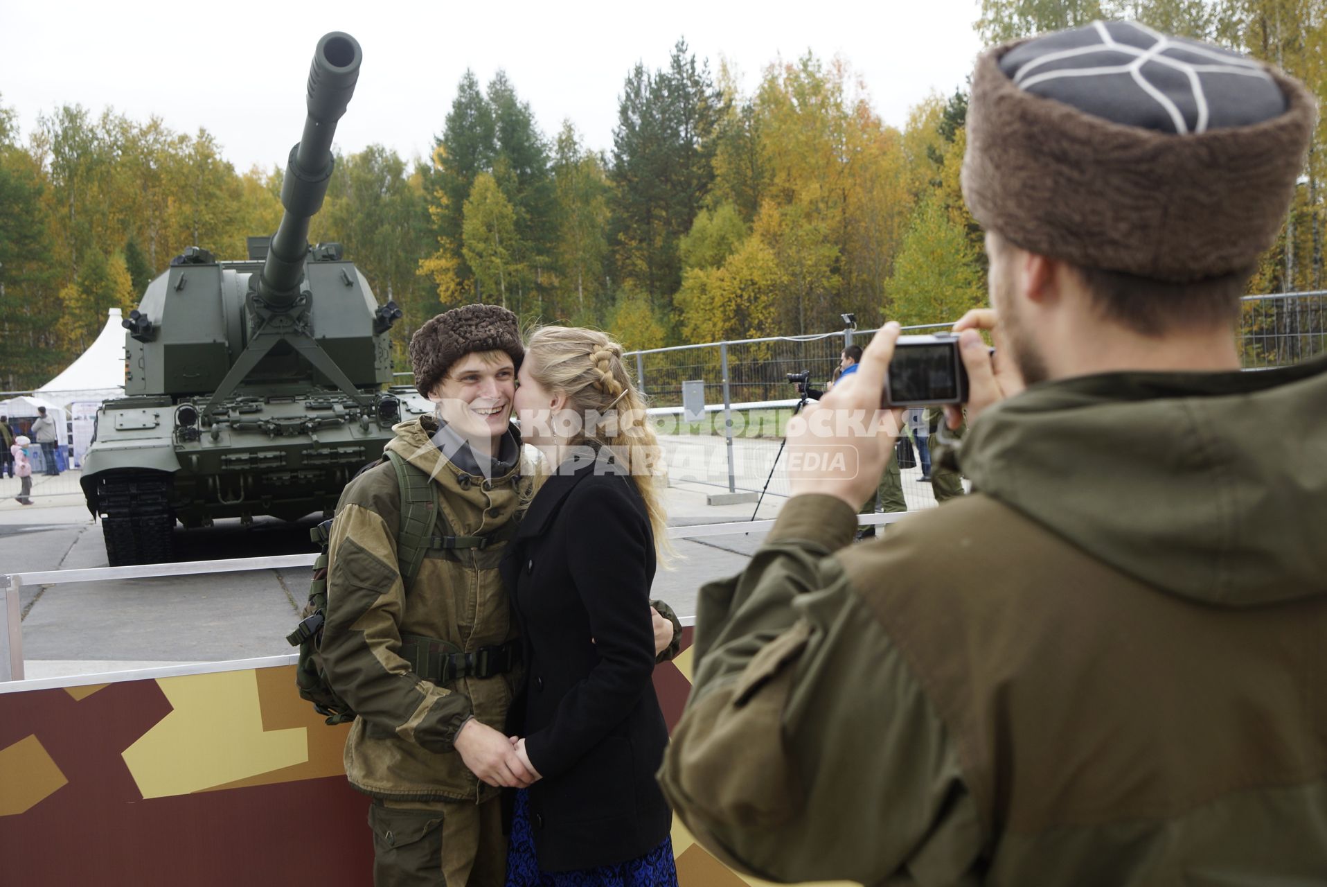 Нижний Тагил. Влюбленная пара фотографируется на фоне самоходной артиллерийской установки `Коалиция-СВ` на 10-ой международной выставке вооружений `Russia Arms Expo - 2015`.