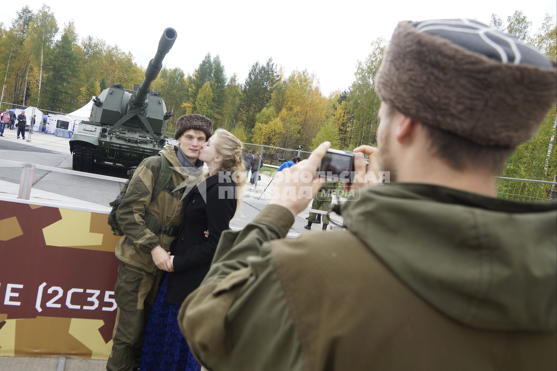 Нижний Тагил. Влюбленная пара фотографируется на фоне самоходной артиллерийской установки `Коалиция-СВ` на 10-ой международной выставке вооружений `Russia Arms Expo - 2015`.