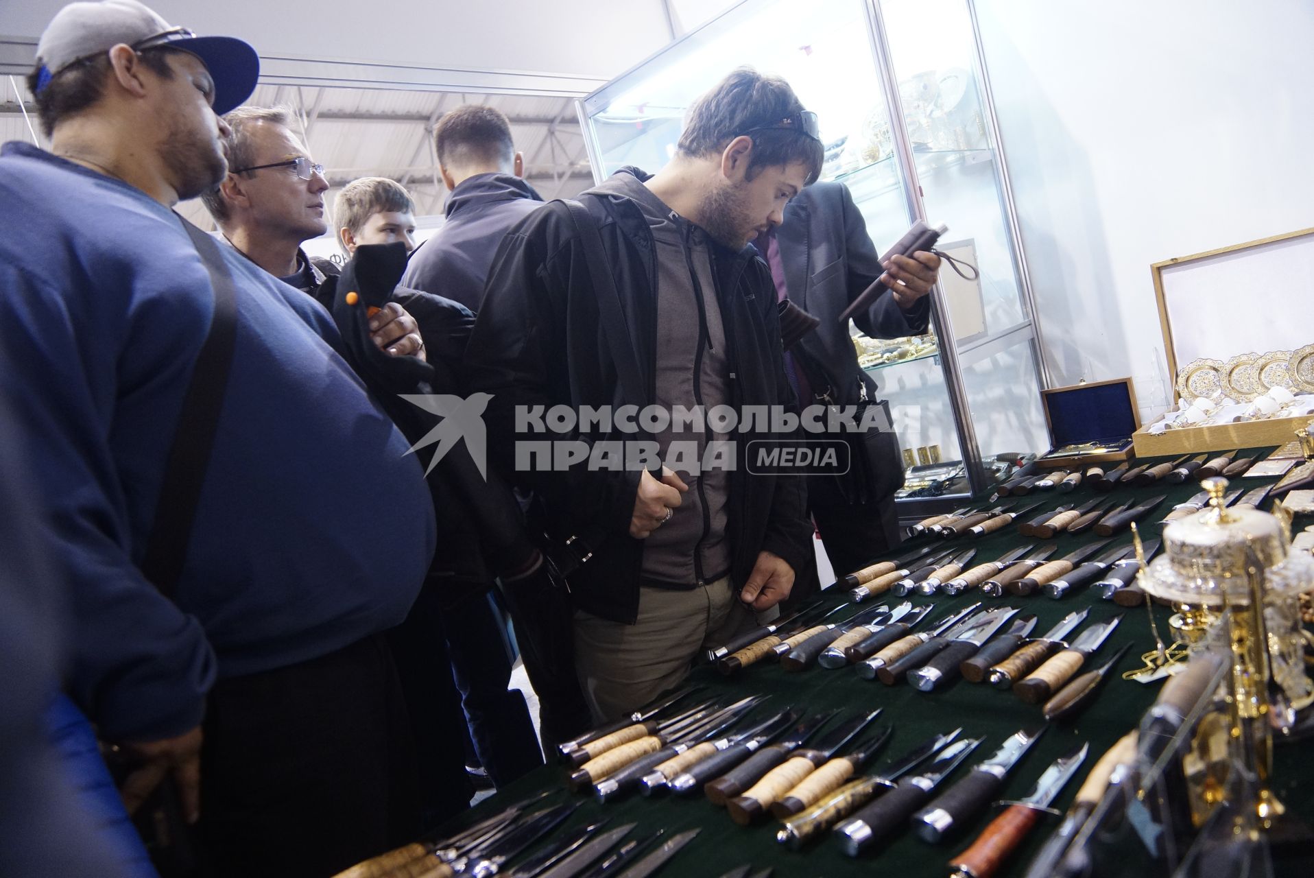 Нижний Тагил. Посетители изучают ножи у стенда `Златоустовской оружейной компании` на 10-ой международной выставке вооружений `Russia Arms Expo - 2015`.