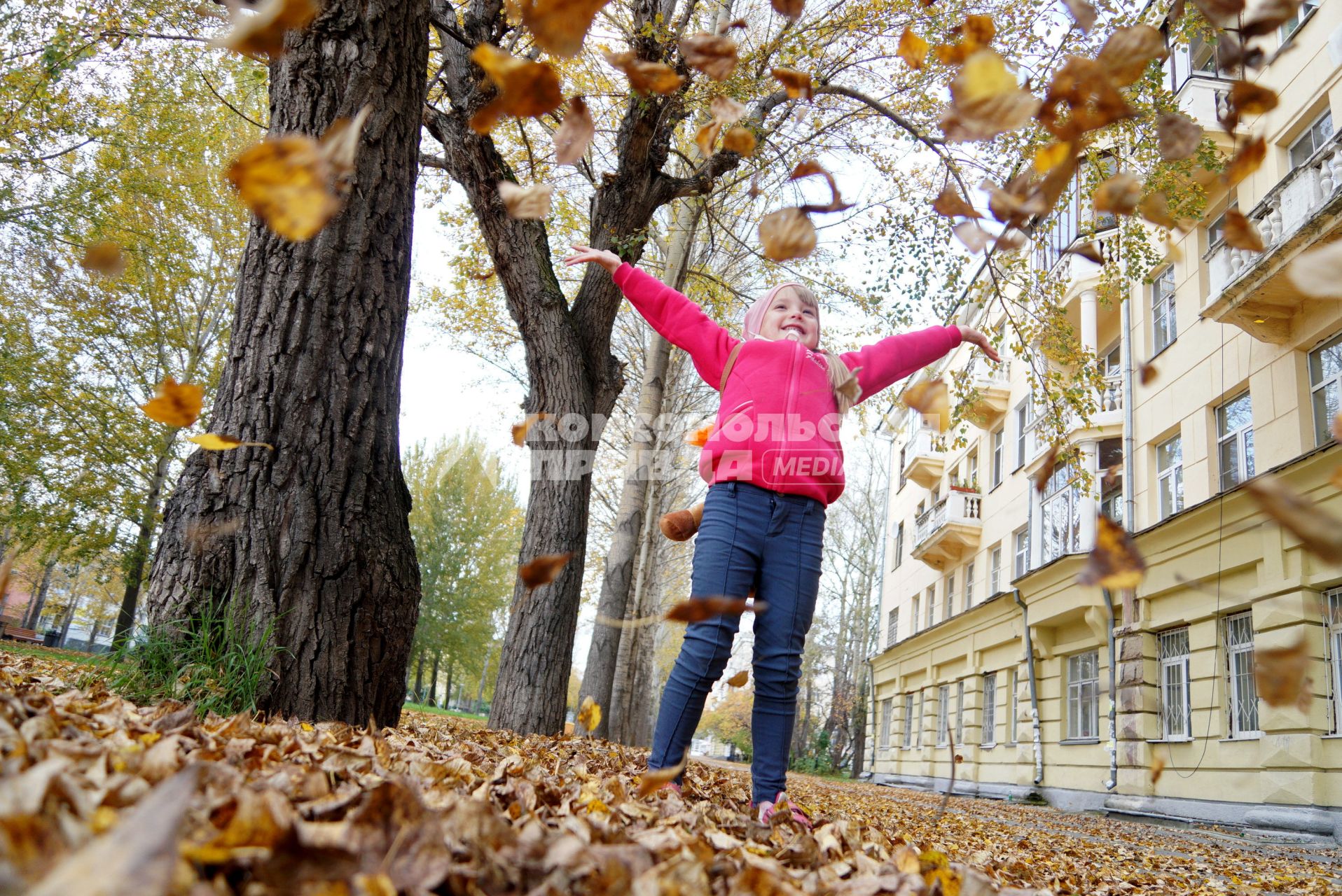 Екатеринбург. Девочка гуляет по парку, усыпанному желтыми опавшими листьями.