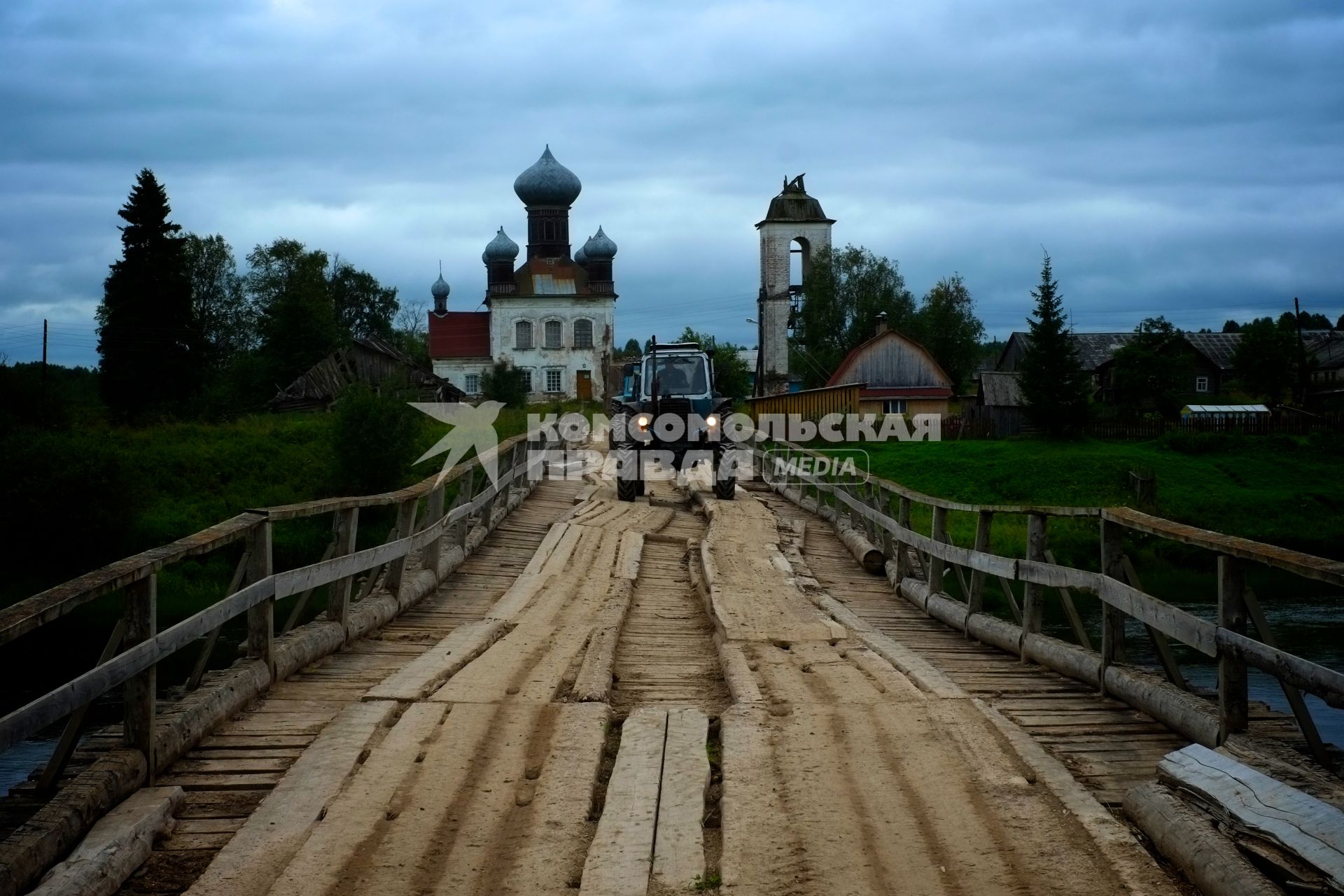 Архангельская область. г.Каргополь. Трактор едет по мосту.