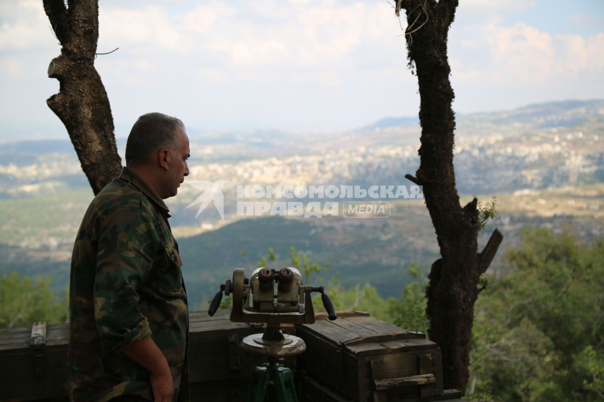 Сирия. д.Баруда. Сирийский военный на наблюдательном пункте следит за движением исламских боевиков, расположенных в г.Сальма.