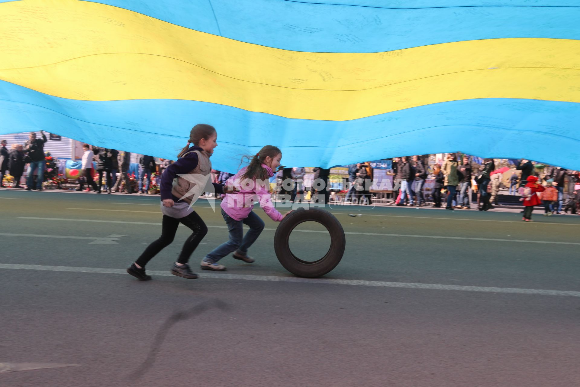 Украина. Киев. Девочки играют с шиной во время проведения митинга.