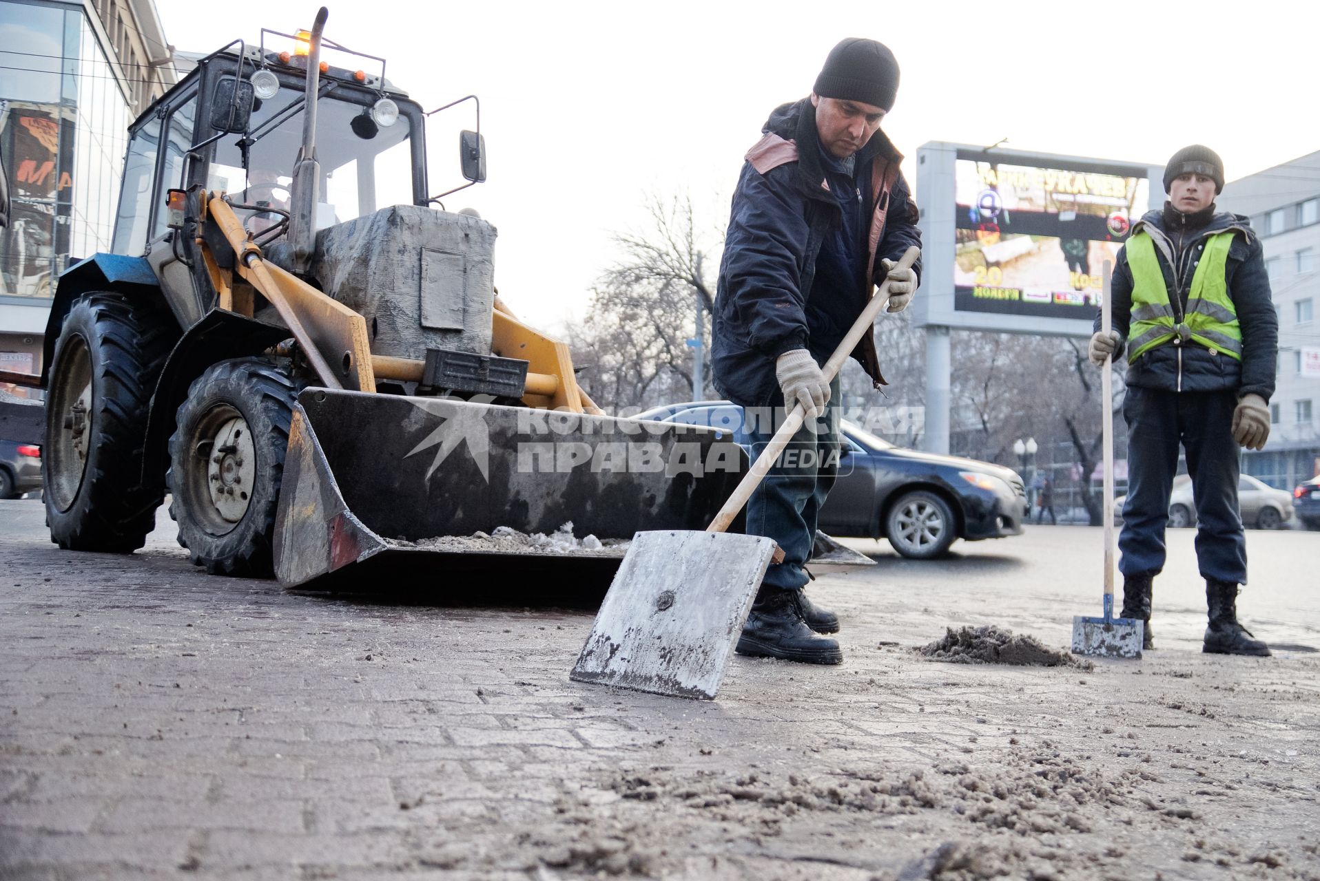 Екатеринбург. Дворники с помощью лопат и трактора убирают снег с улицы.