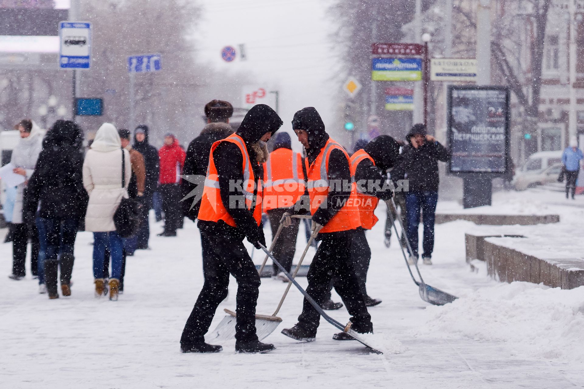 Екатеринбург. Гастарбайтеры убирают снег лопатами во время снегопада.