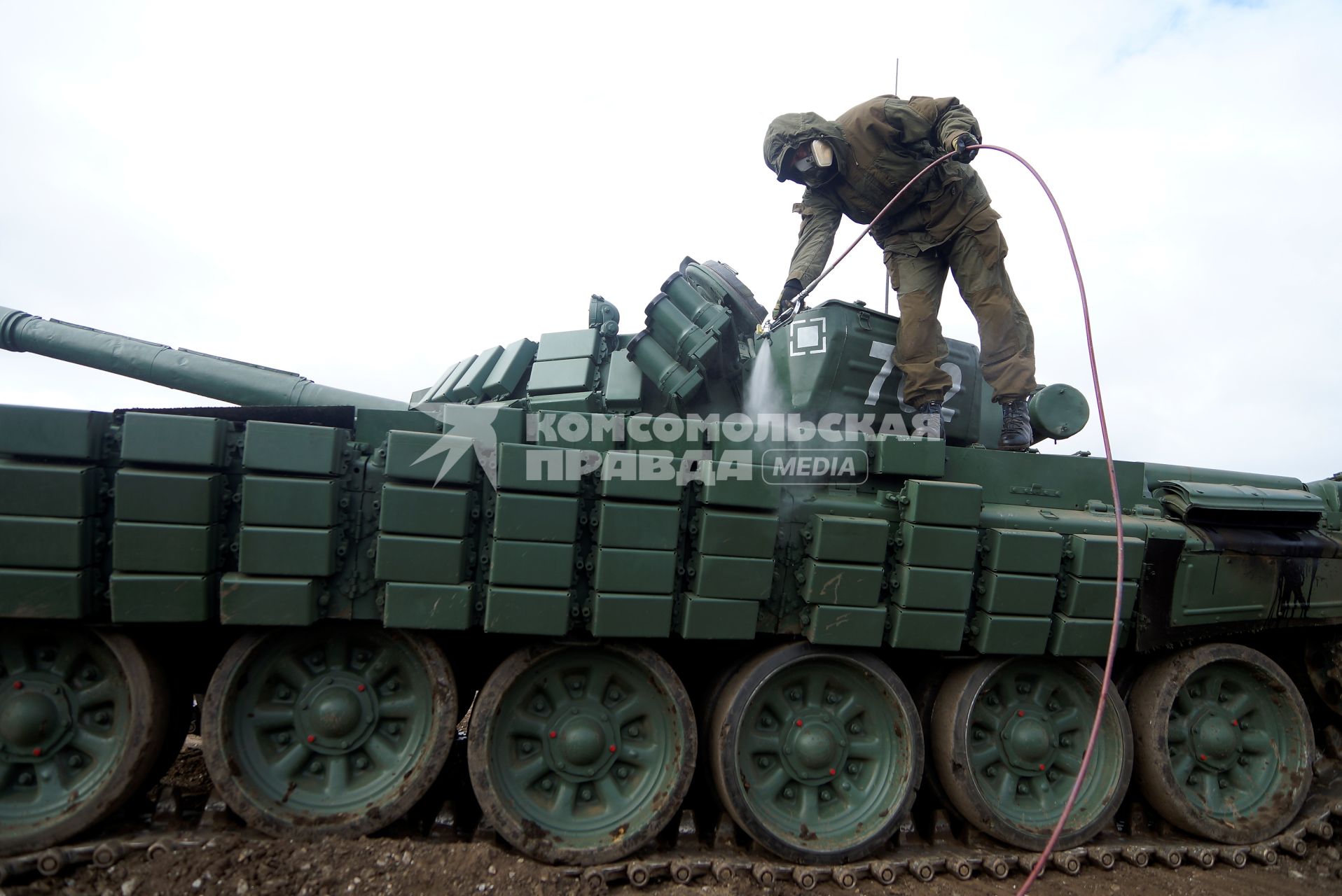 Челябинская область. Чебаркульский военный полигон. Военнослужащий поливает растворителем танк Т-72 в ходе испытания краски с антиобледенительным, маскировочным и радиодезактивирующим свойствами.