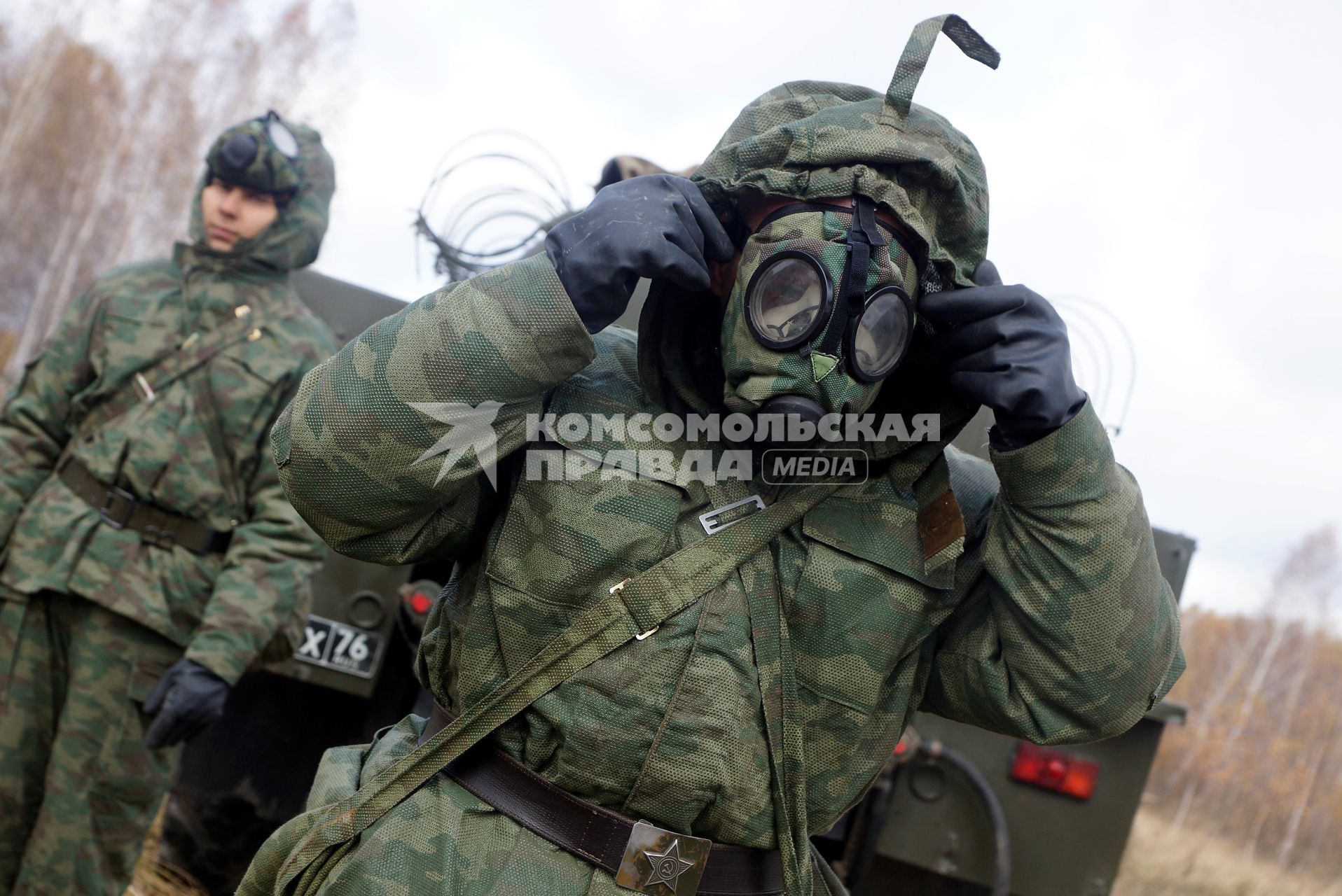 Челябинская область. Чебаркульский военный полигон. Военнослужащий одевает респиратор перед началом противорадиационной обработки танка, в ходе испытания краски с антиобледенительным, маскировочным и радиодезактивирующим свойствами.