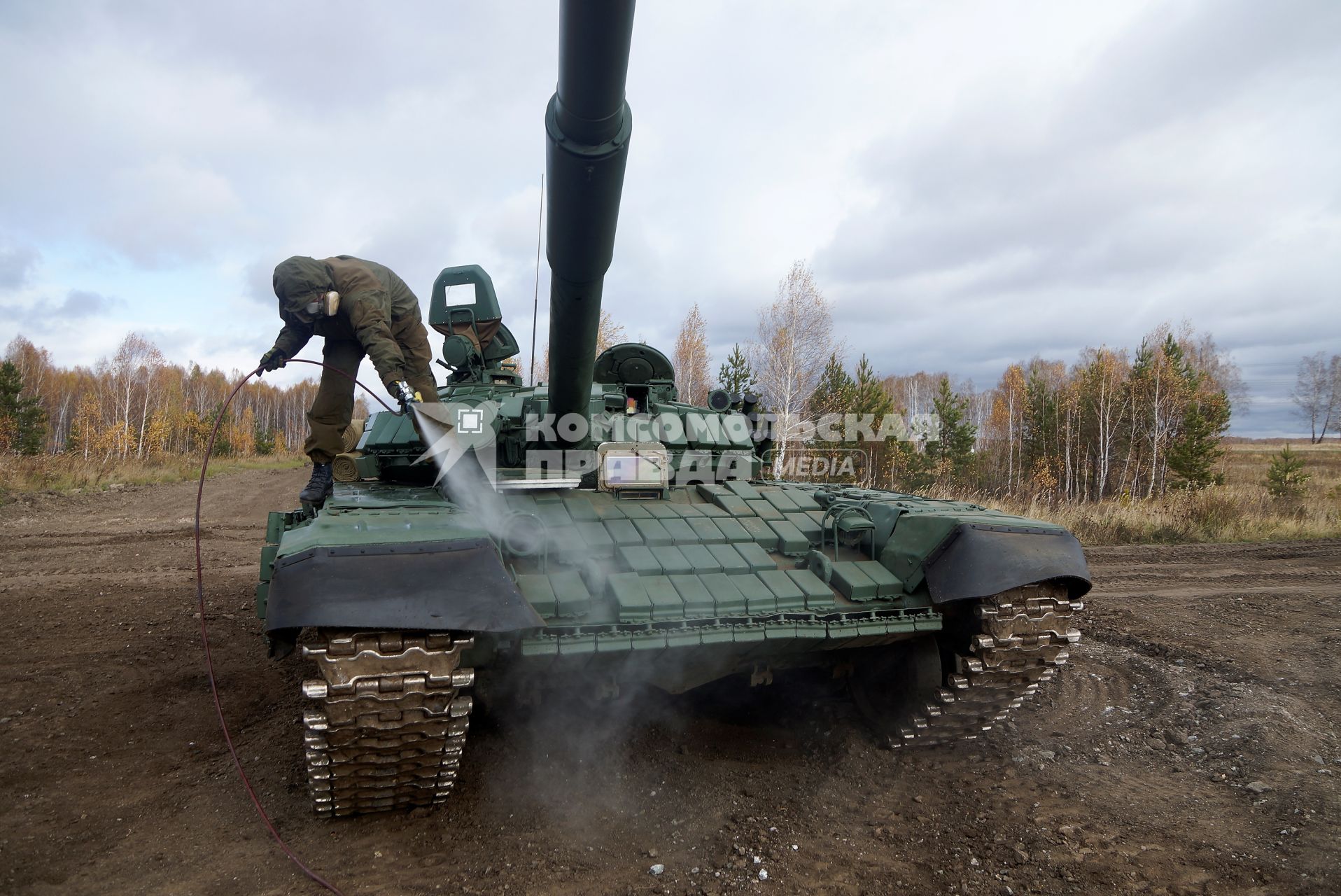 Челябинская область. Чебаркульский военный полигон. Военнослужащий поливает растворителем танк Т-72 в ходе испытания краски с антиобледенительным, маскировочным и радиодезактивирующим свойствами.