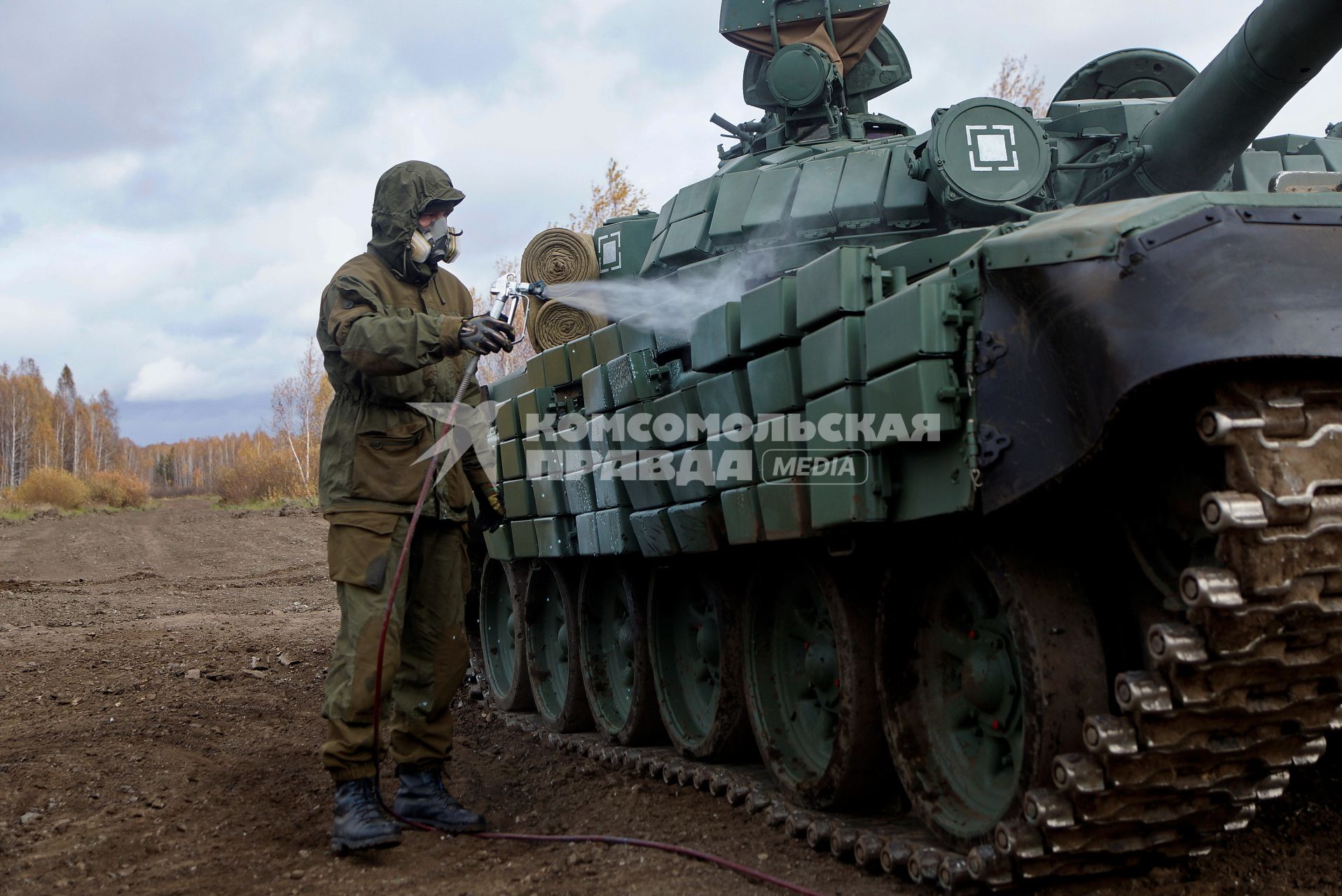 Челябинская область. Чебаркульский военный полигон. Военнослужащий поливает растворителем танк Т-72 в ходе испытания краски с антиобледенительным, маскировочным и радиодезактивирующим свойствами.