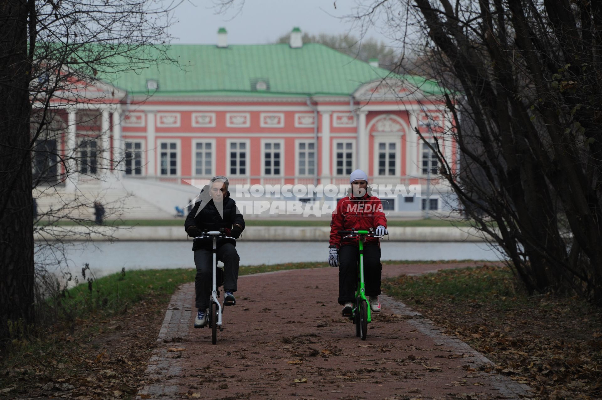 Москва.  Усадьба Кусково. Женщины катаются на велосипеде в парке.