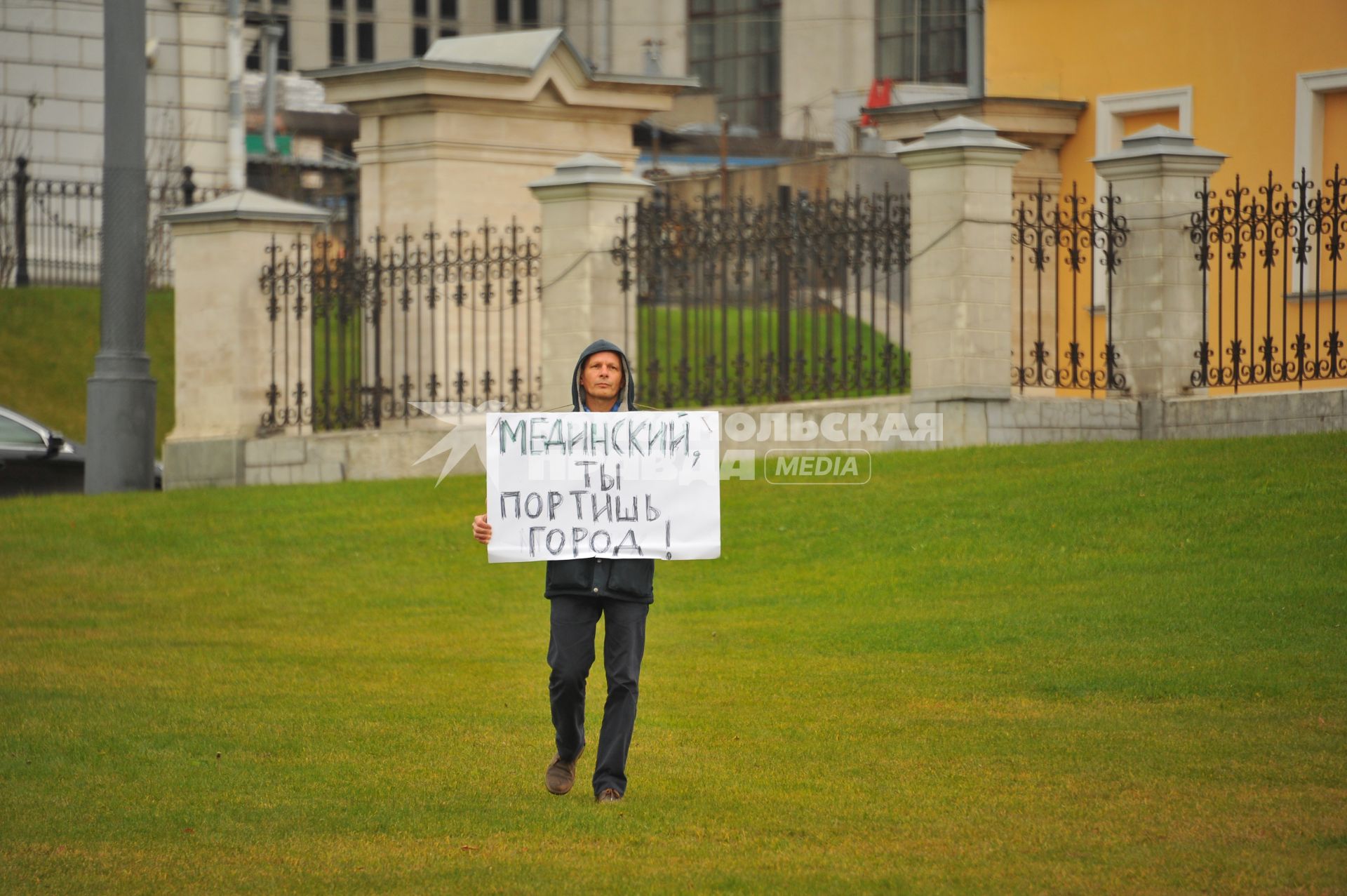 Москва.  Активист  Валентин Карелин держит плакат  `Мединский ты портишь город!` во время одиночного пикета рядом с местом  установки памятника святому равноапостольному князю Владимиру на Боровицкой площади.