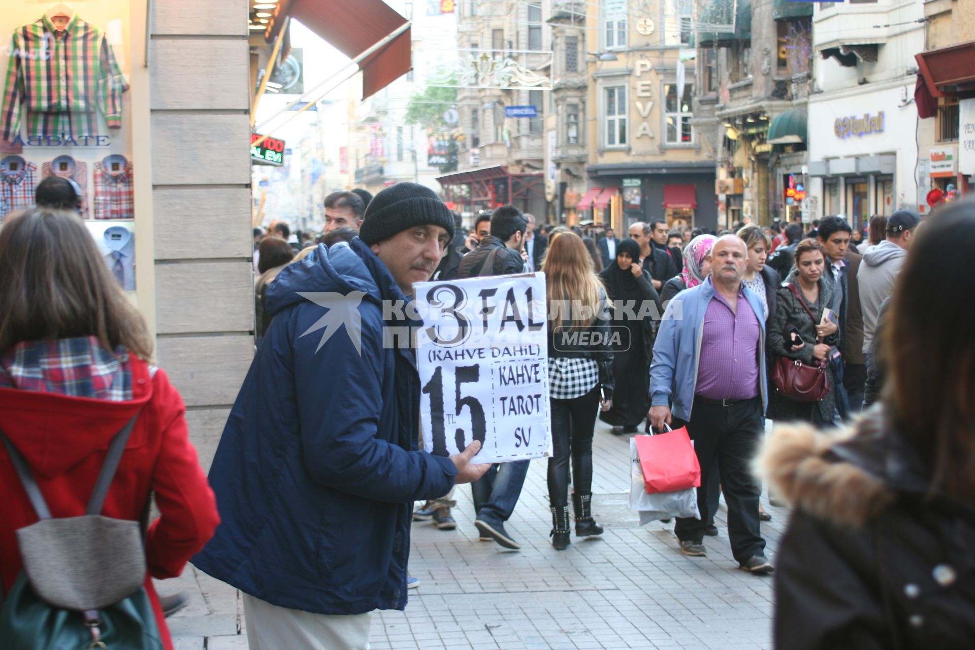 Турция, Стамбул. Мужчина с рекламой трех видов гадания - на кофейной гуще, картах таро и руке.