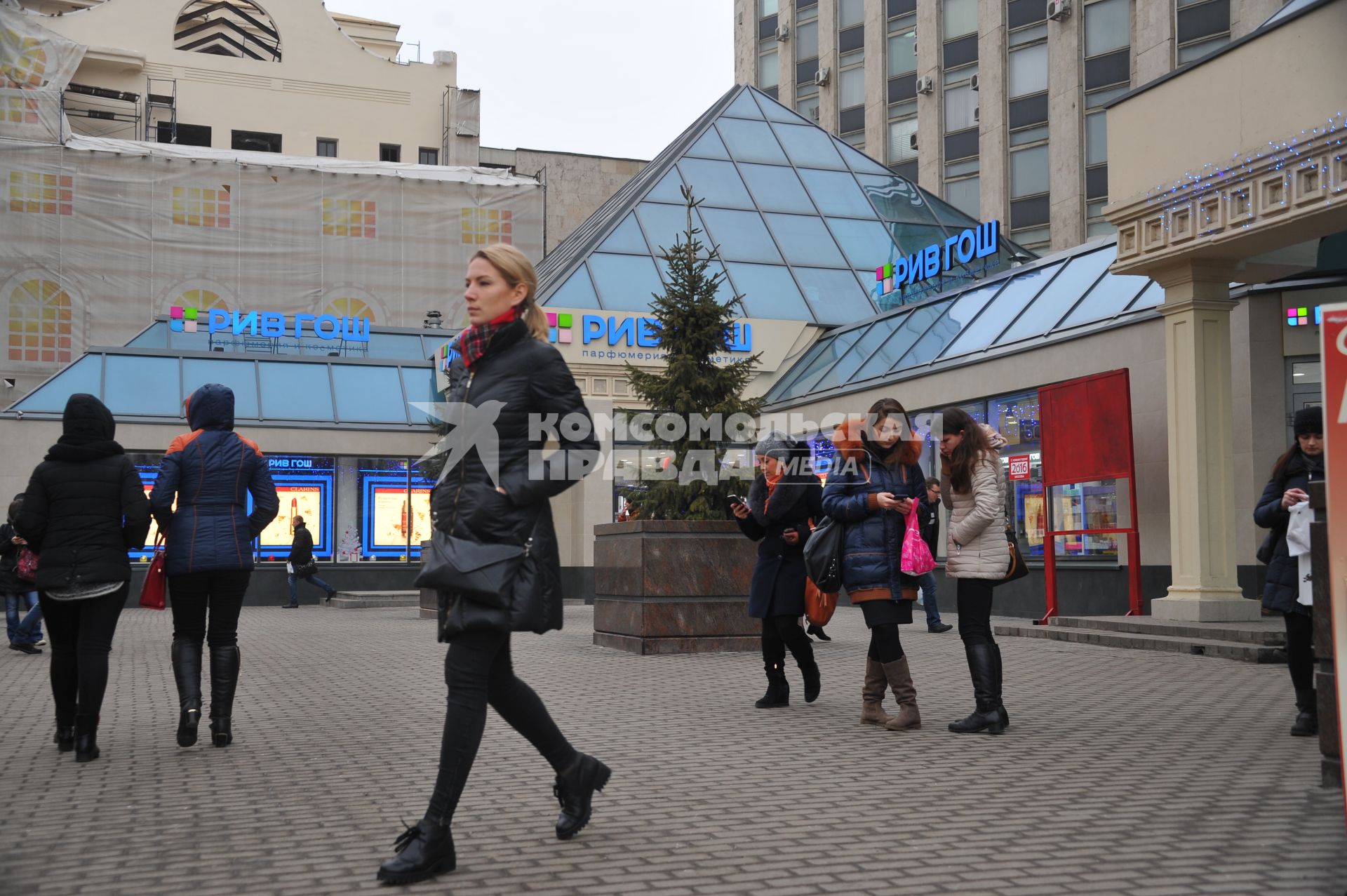 Москва.  Прохожие у торгового центра  `Пирамида` на Тверской улице.