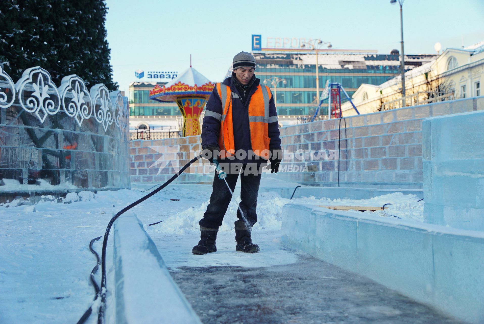 Екатеринбург. Рабочий заливает лед у горки во время строительства ледового городка на `Площади 1905 года`.
