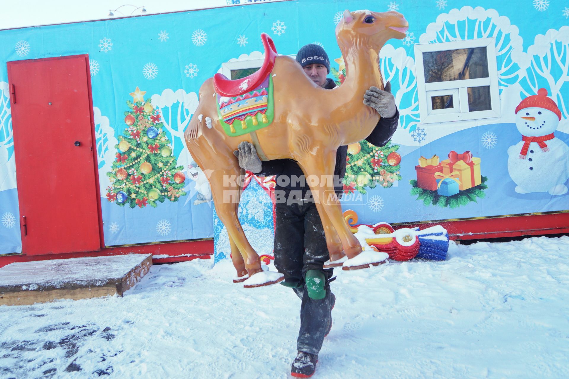 Екатеринбург. Рабочий устанавливает верблюда на карусель во время строительства ледового городка на `Площади 1905 года`.