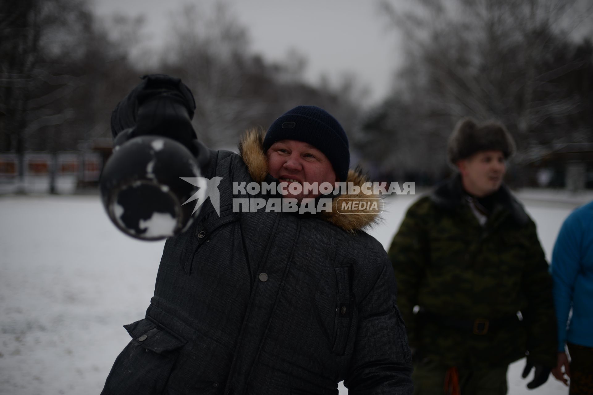 Москва. Мужчина подкидывает гирю в парке Кузьминки.