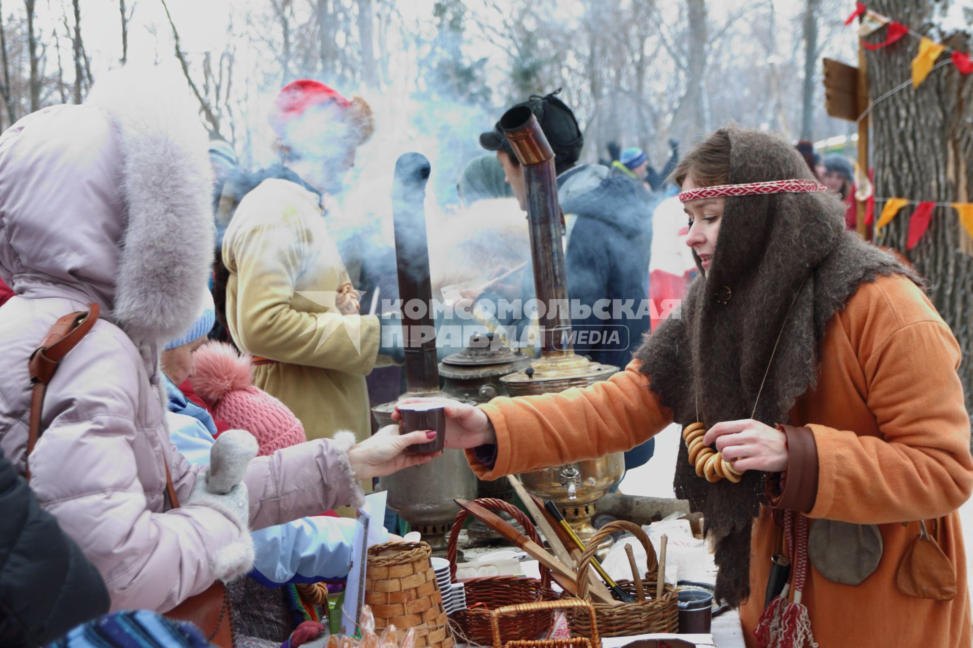 Самара. Фестиваль `Славянская зима` в культурном центре `Светлица`. Девушка угощает горячим чаем из настоящего русского самовара.