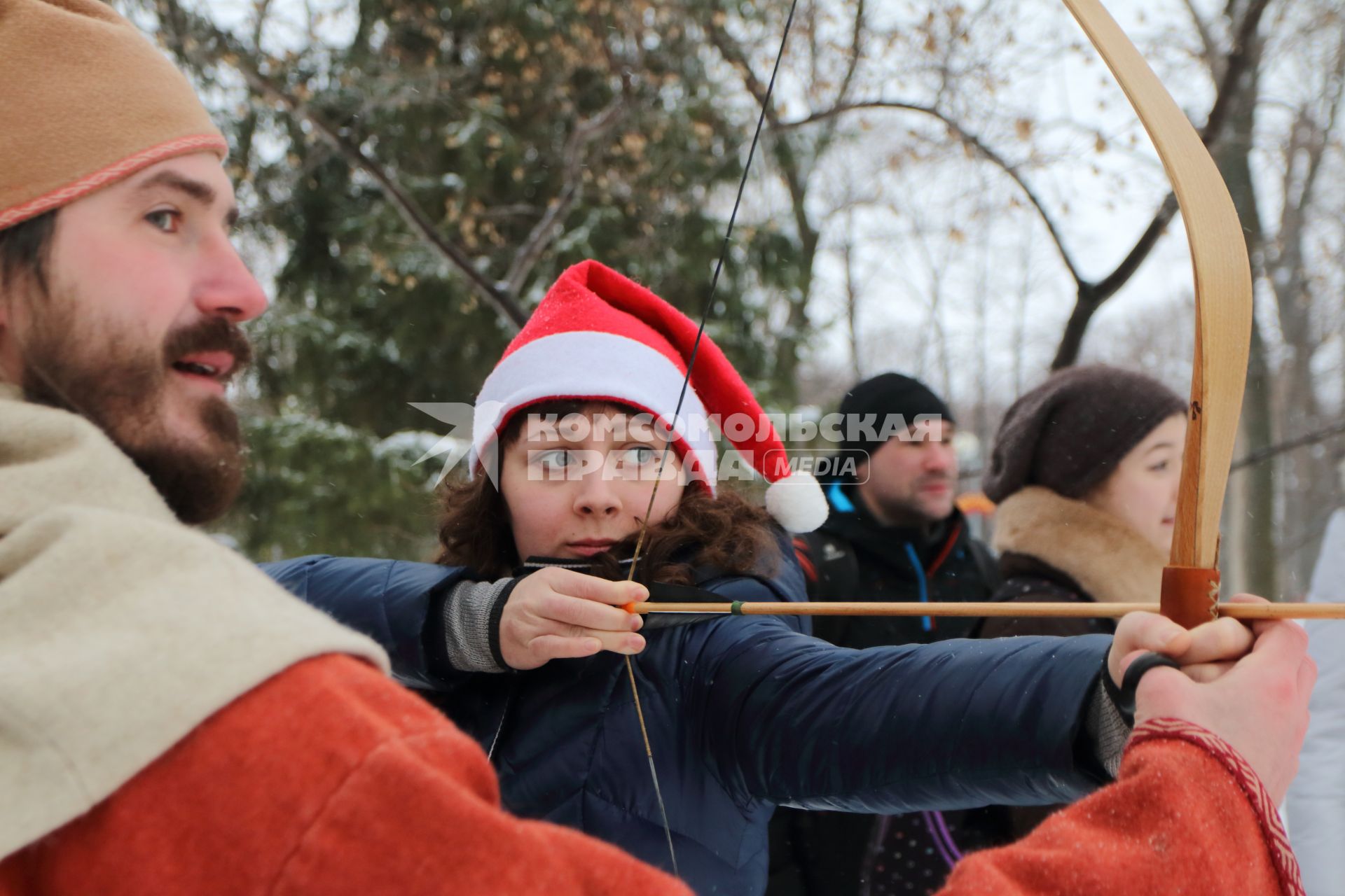 Самара. Фестиваль `Славянская зима` в культурном центре `Светлица`. Девушка учится стрелять из лука.